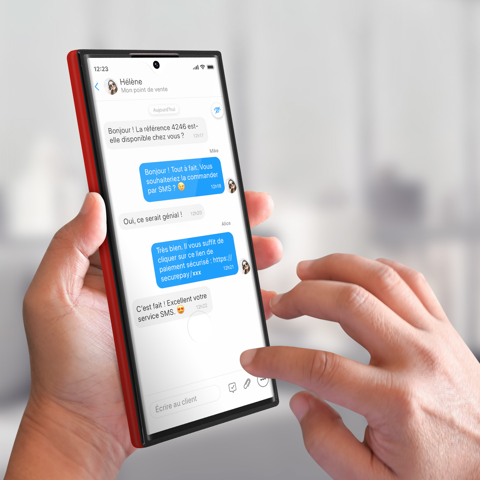 Une personne tenant un téléphone avec une conversation texte à l'écran. Le téléphone a une coque rouge.