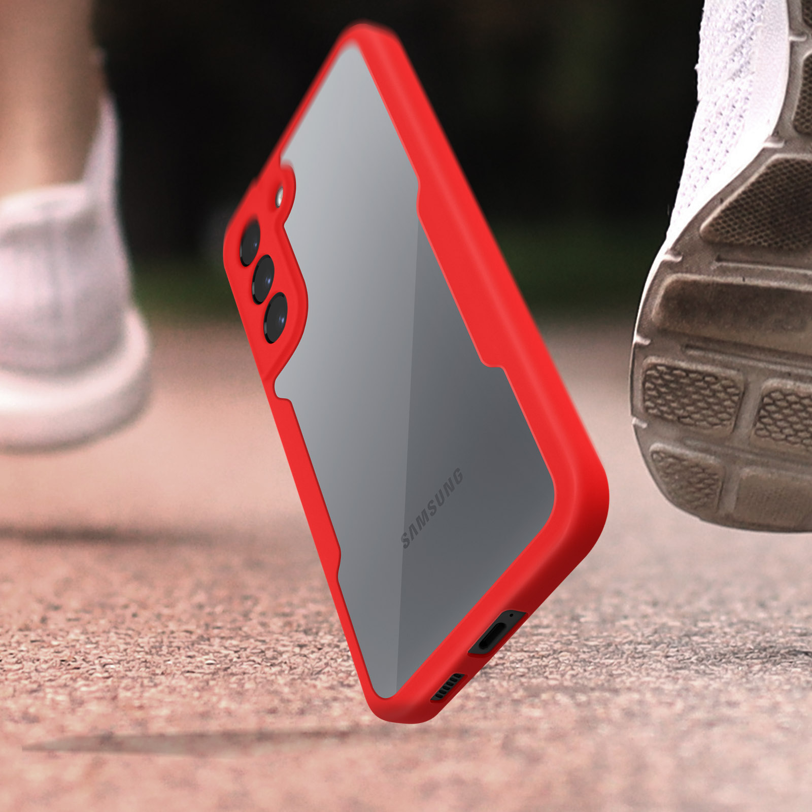 Una custodia rossa per telefono è angolata vicino alla scarpa da corsa di una persona, su una superficie grigia.