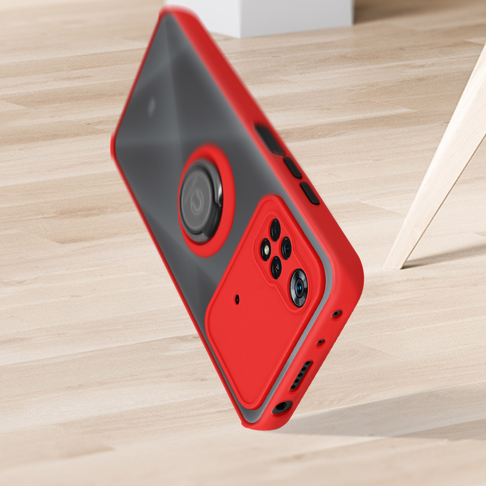 Un étui de téléphone rouge avec un téléphone à l'intérieur. Le téléphone a des caméras. L'étui tombe, avec un fond en bois.