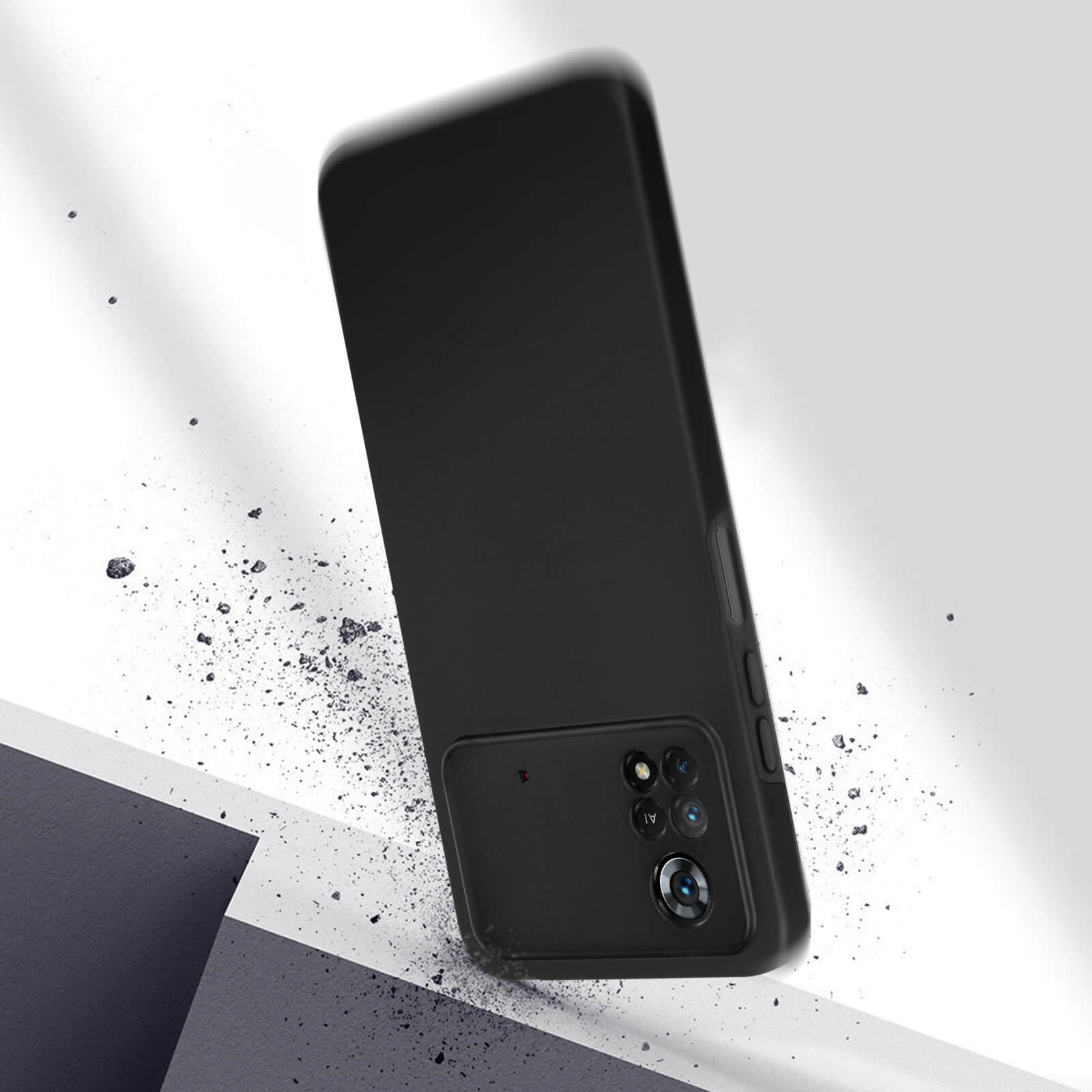 Une coque de téléphone noire qui tombe. De petits débris se dispersent autour du téléphone. Le fond est blanc.