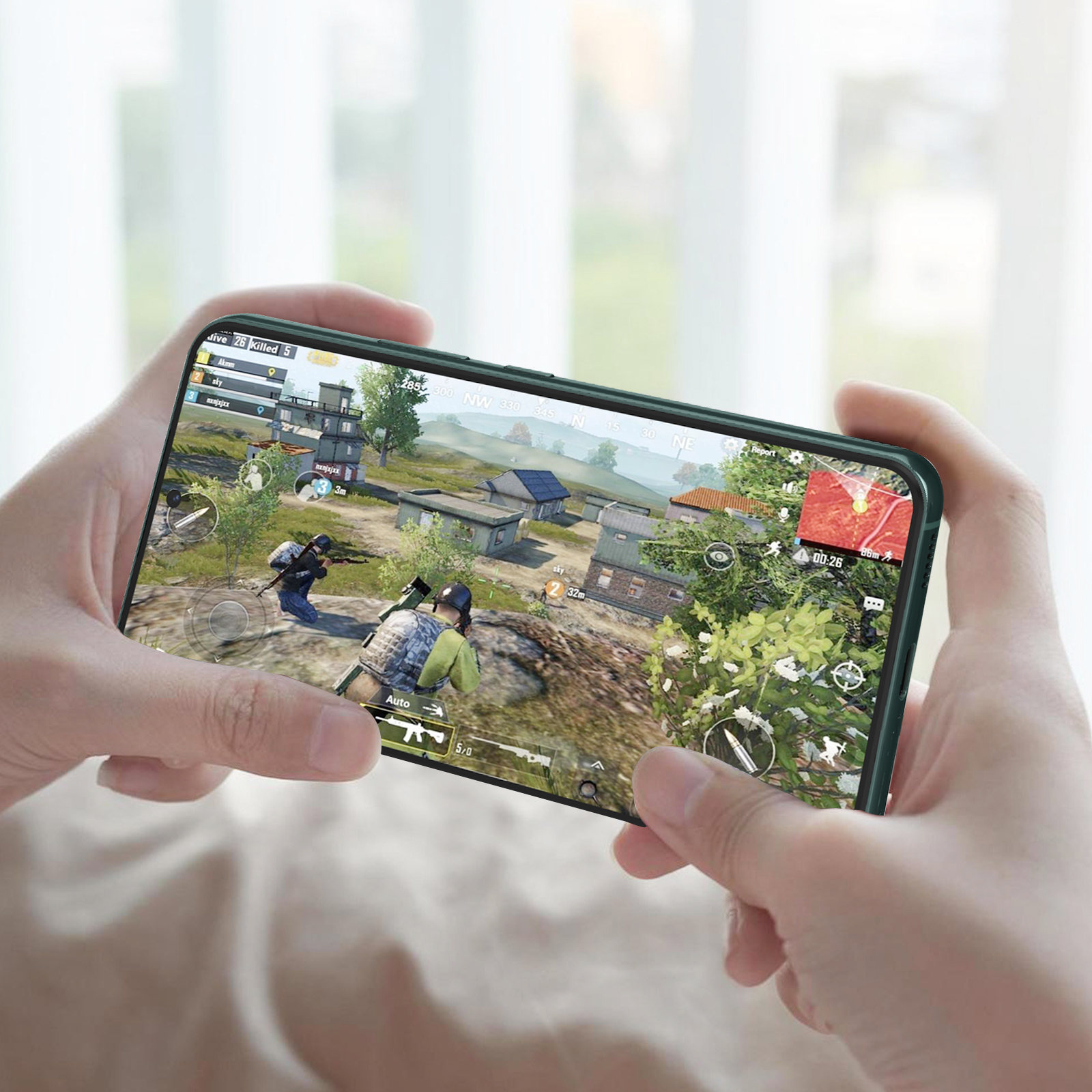 Personne tenant un téléphone jouant à un jeu. Le téléphone a un étui vert.