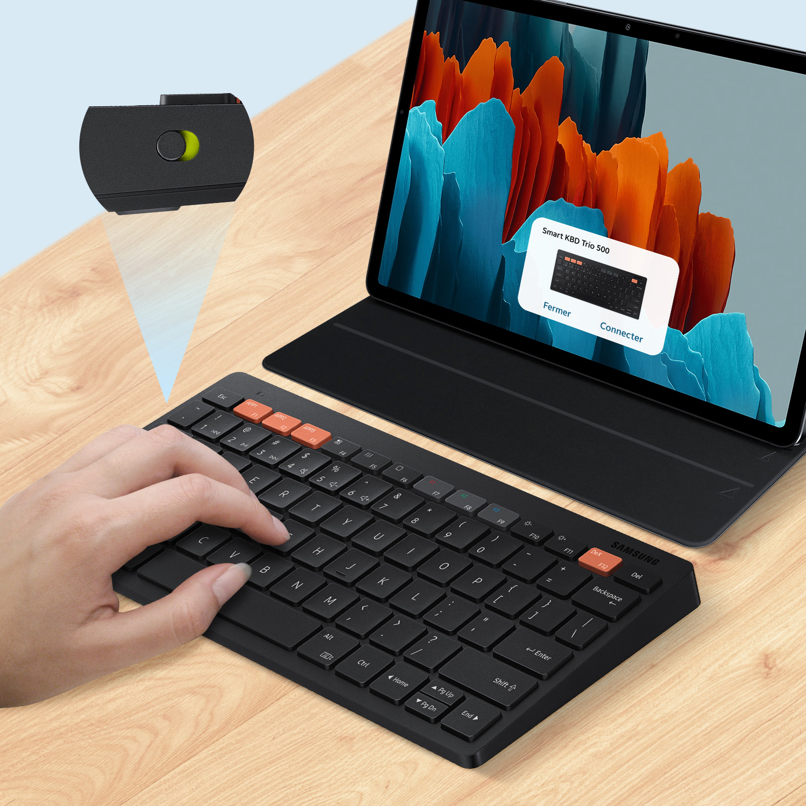Una mano presiona un teclado. Una tableta con un aviso de conexión de teclado está detrás del teclado.