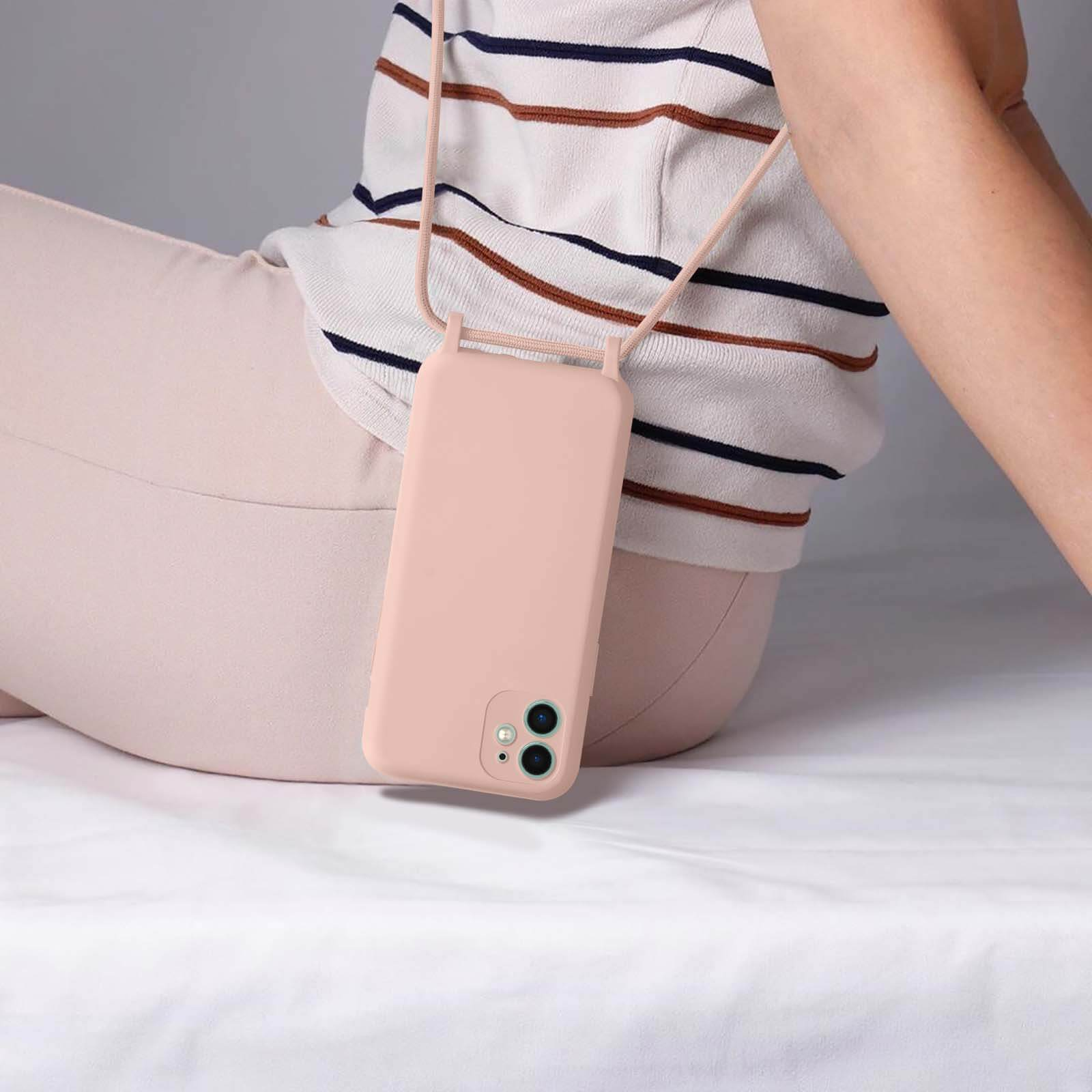 Une personne porte un étui de téléphone rose clair avec une sangle rose. Pantalon rose clair et chemise rayée.
