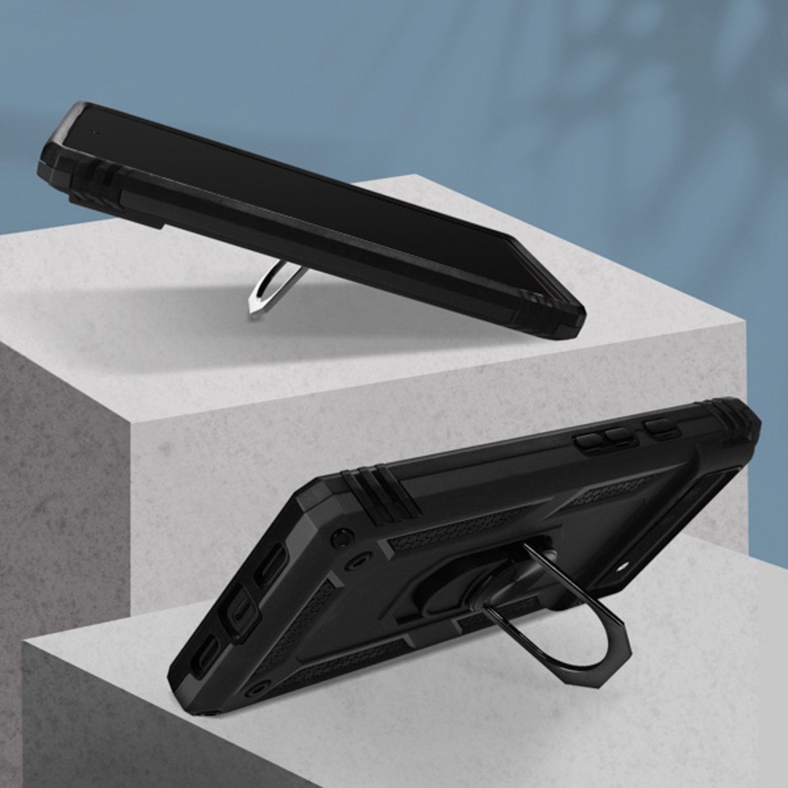 Deux étuis de téléphone noirs avec des supports d'anneau, sur une surface blanche. Ils sont inclinés.