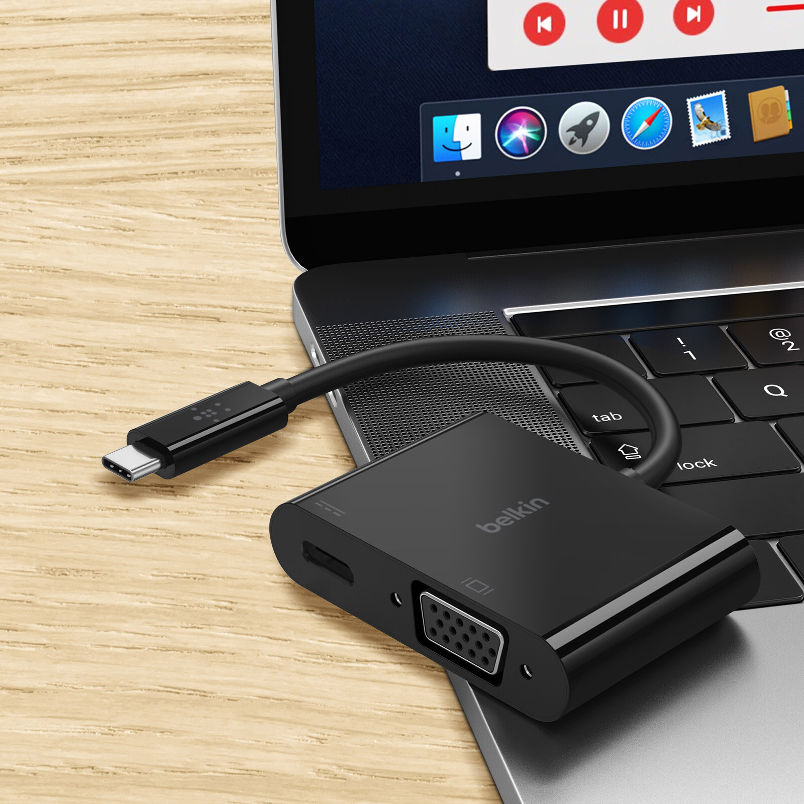 Un adattatore Belkin nero è collegato a un laptop. Ha USB-C, VGA e altre porte visibili.