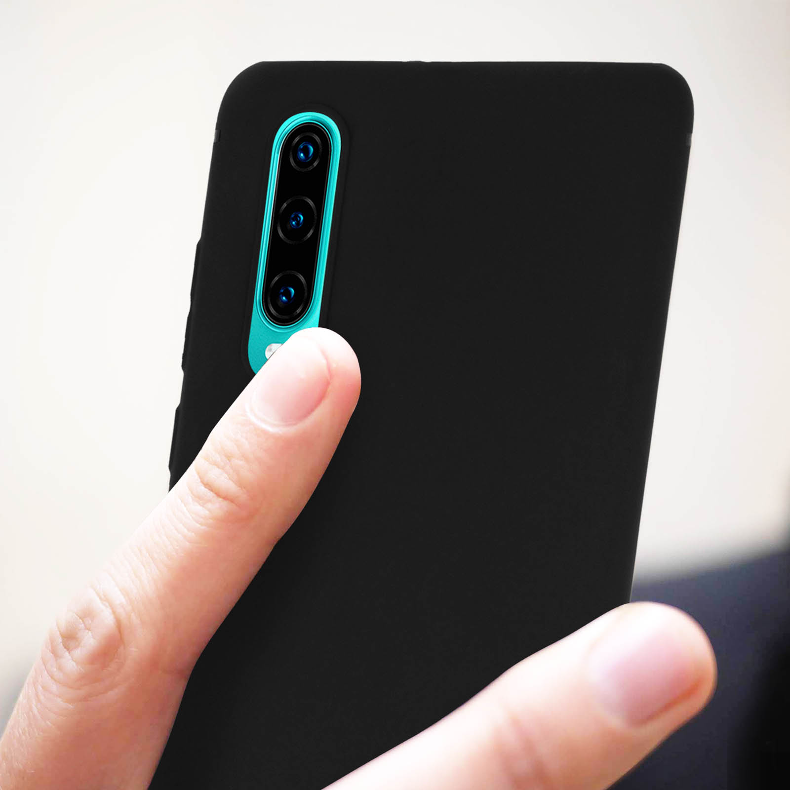 Telefono nero con tre fotocamere. Una mano tiene il telefono. Lo sfondo è sfocato.