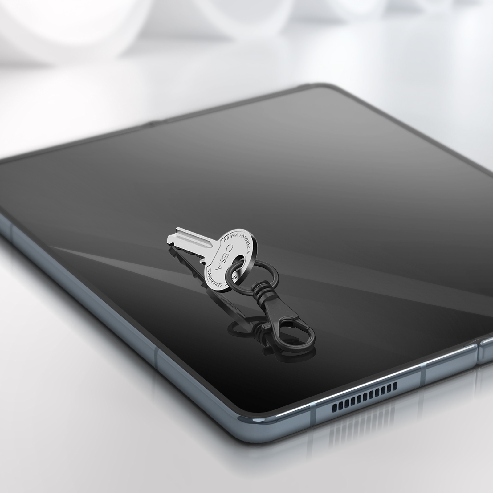 Una chiave su un tablet nero. Il tablet è su una superficie bianca.