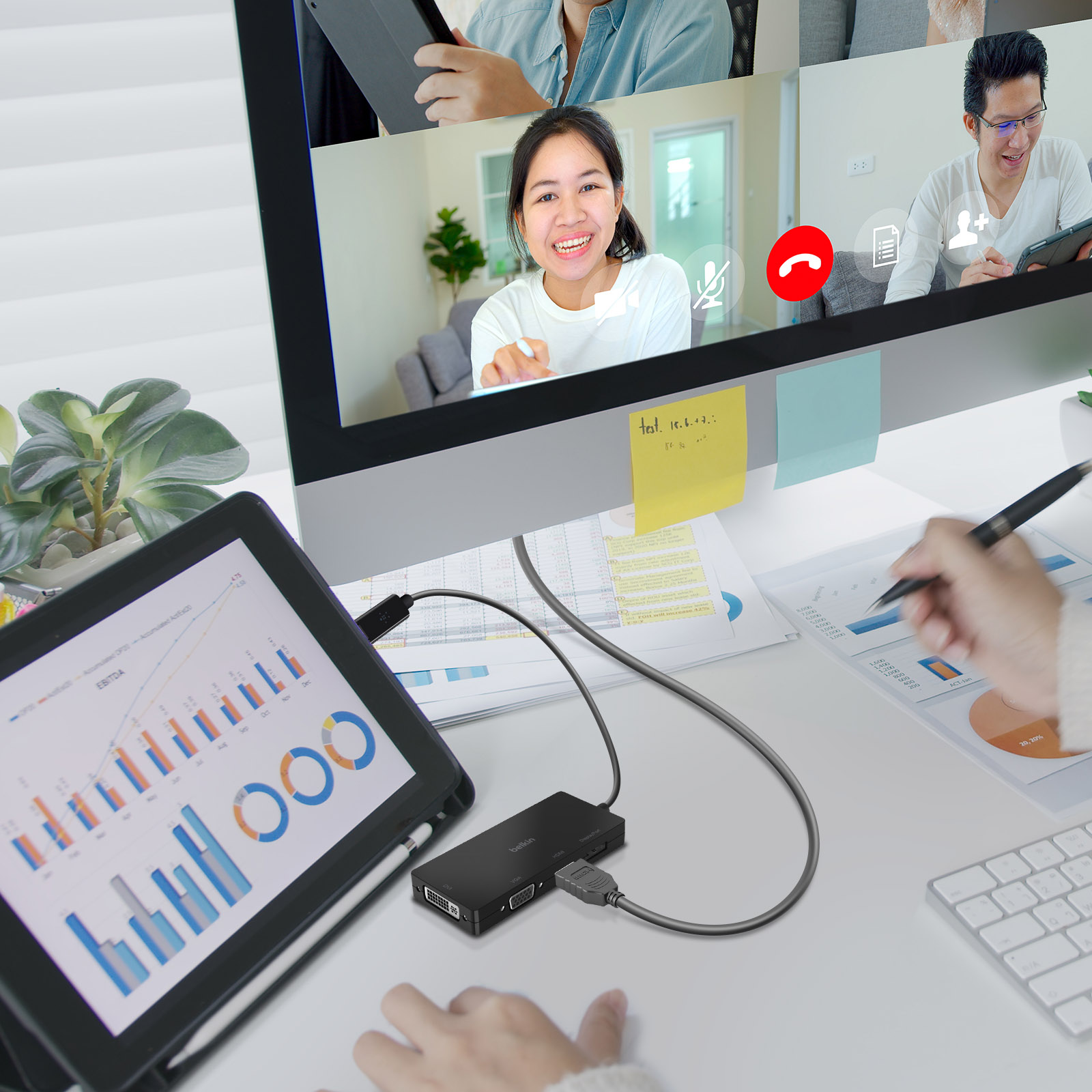 Persone in una videochiamata, con un tablet e un computer su una scrivania.