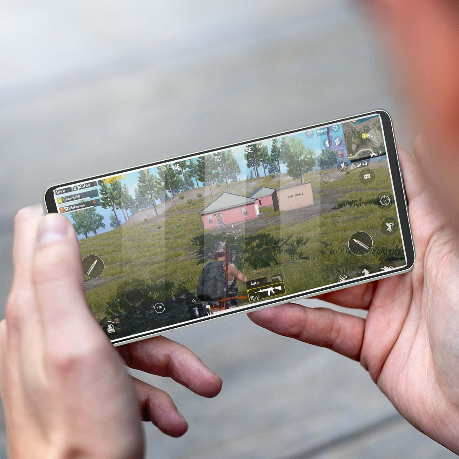 Mani che tengono un telefono che mostra un gioco. Il gioco ha una visuale orizzontale.