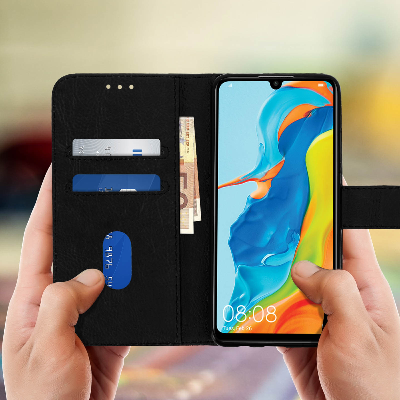 Custodia nera per telefono che contiene telefono, denaro e carte. Il telefono mostra l'ora e la data.