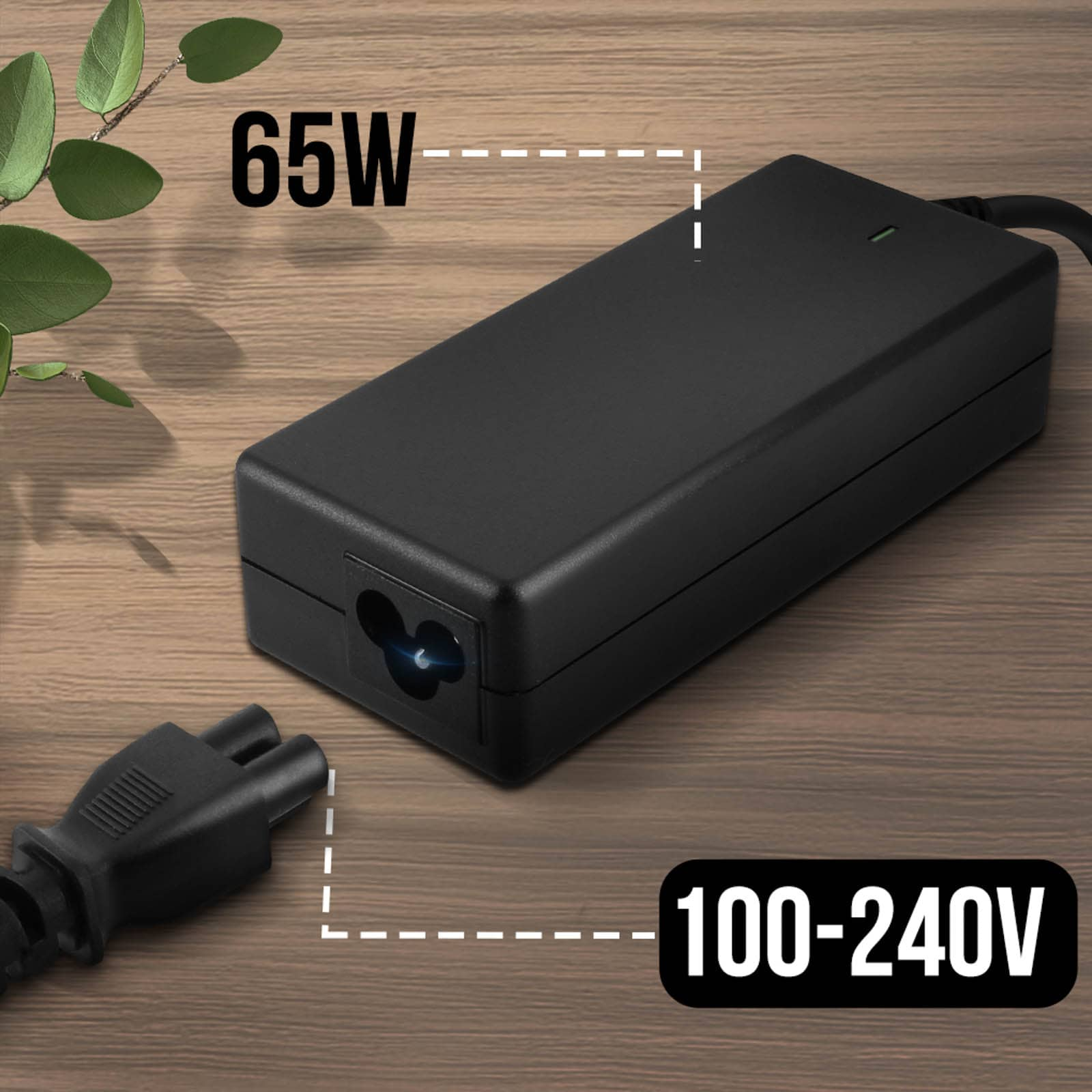 Cargador de laptop negro con etiqueta 65W y 100-240V. Sobre mesa de madera.