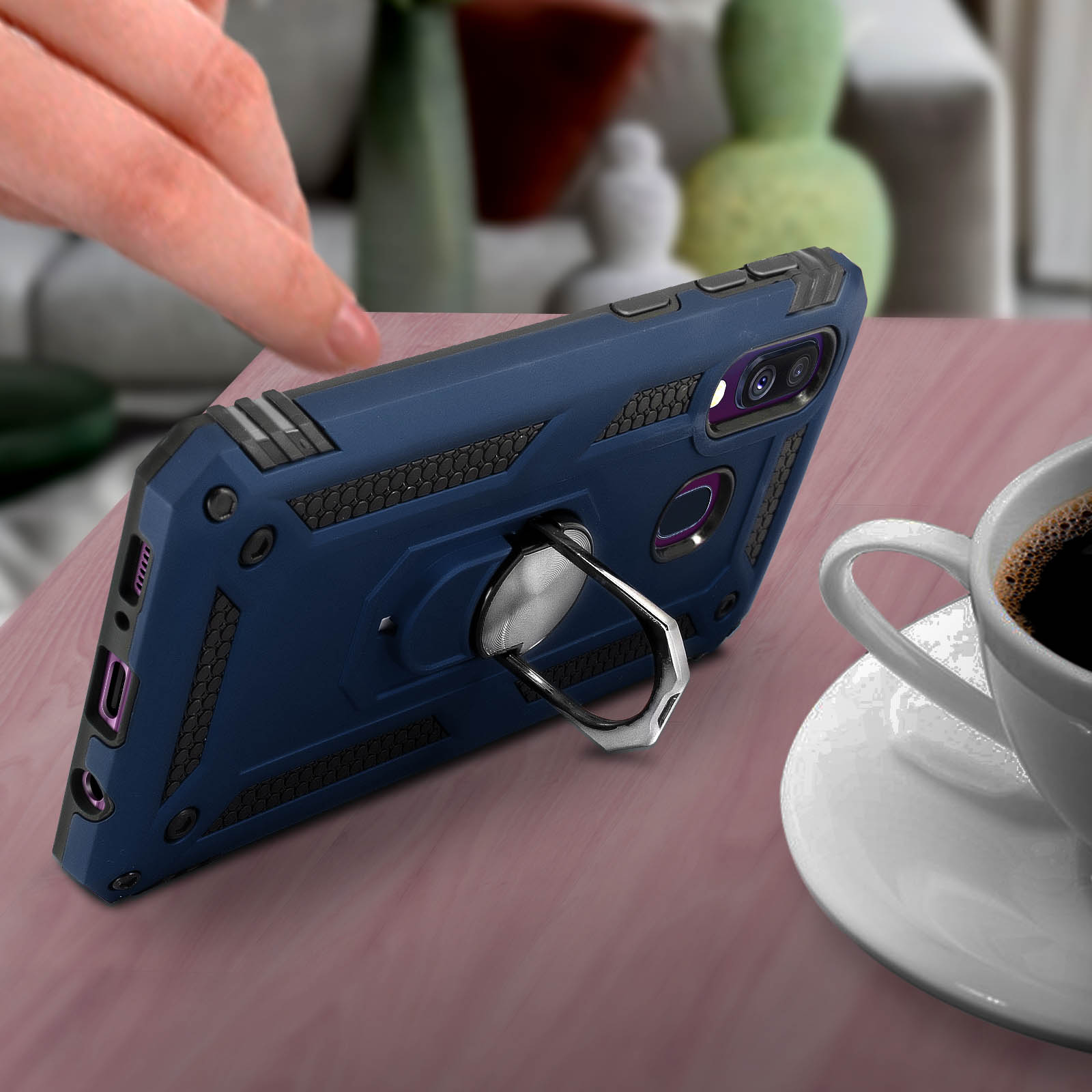 Custodia blu sul tavolo con tazza di caffè e mano.