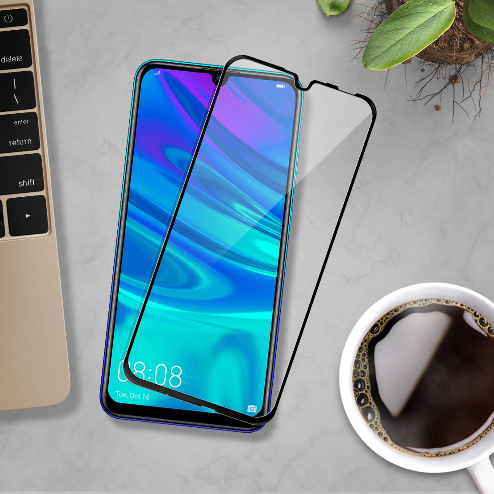 Un telefono con protezione schermo, una tazza di caffè e un laptop. Lo schermo del telefono mostra un orologio e icone.