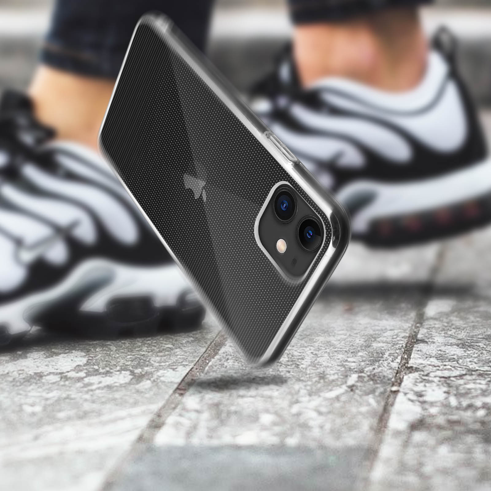 Transparante telefoonhoes op een telefoon, op een getextureerd oppervlak. Schoenen zichtbaar op de achtergrond.