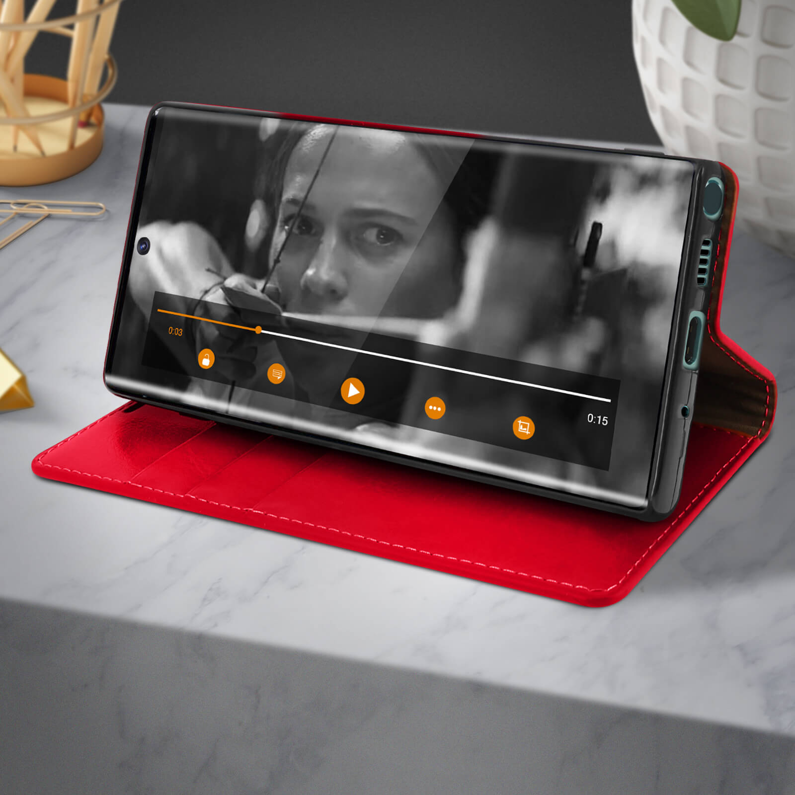 Téléphone diffusant une vidéo, posé sur une table. L'écran affiche une femme, une minuterie et des commandes vidéo.