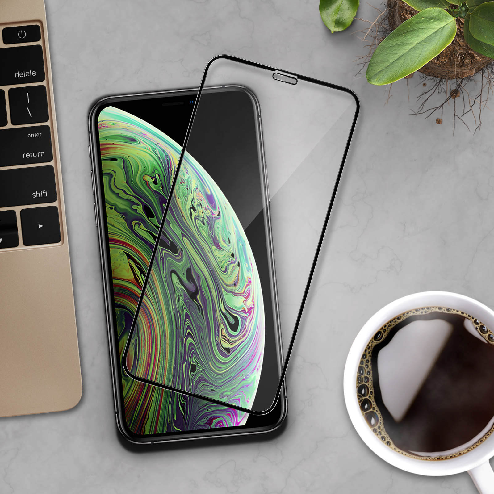 Un telefono con protezione schermo, una tazza di caffè e un laptop. Lo schermo mostra uno sfondo colorato.