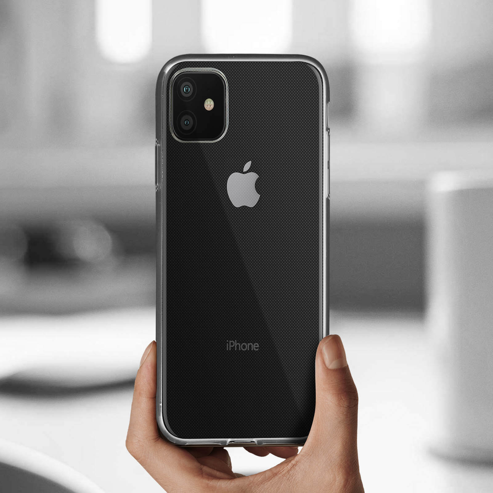 Person hält Telefon in klarer Hülle. Das Telefon hat Apple-Logo.