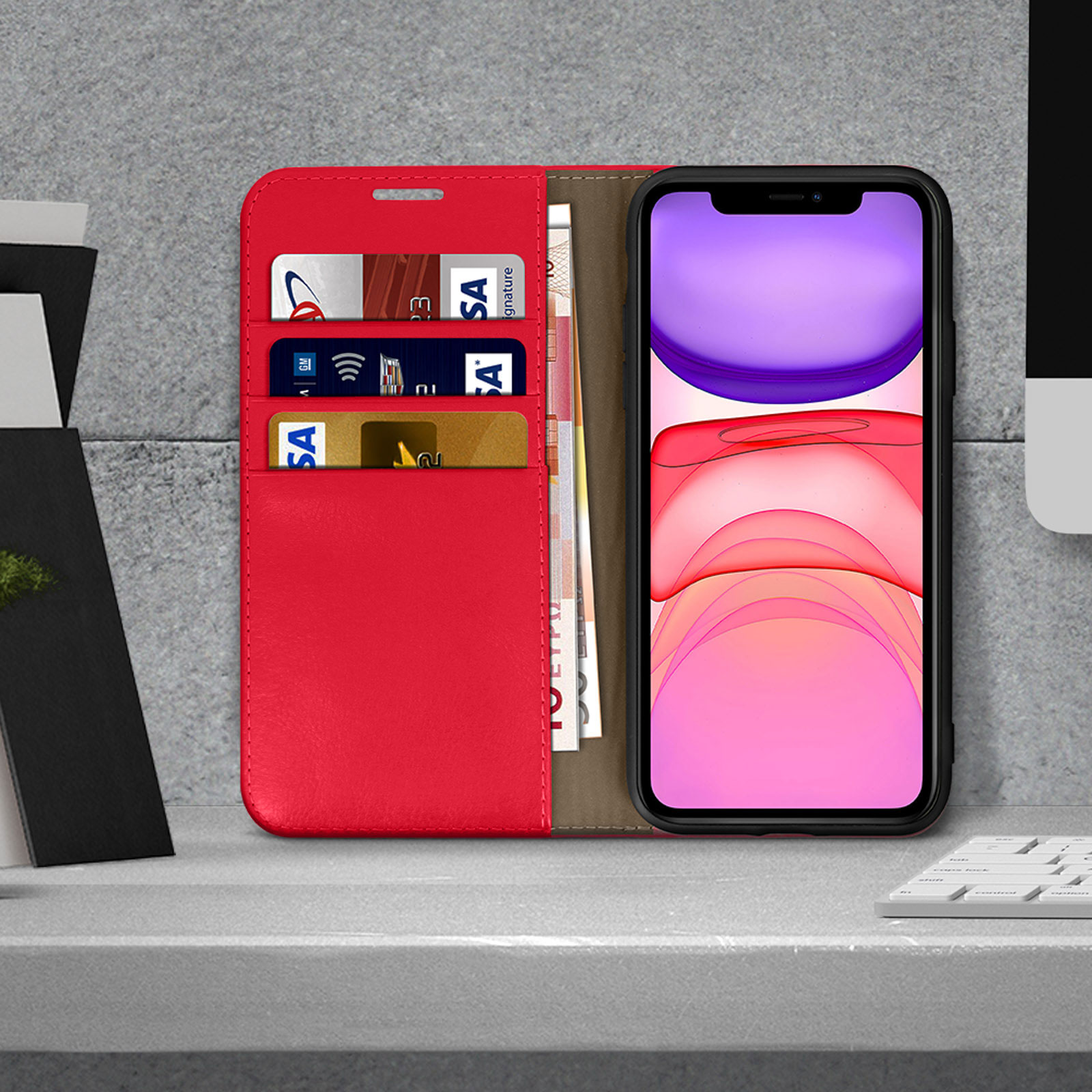 Telefoon in een rode leren hoes op een bureau, met kaarten en geld zichtbaar.