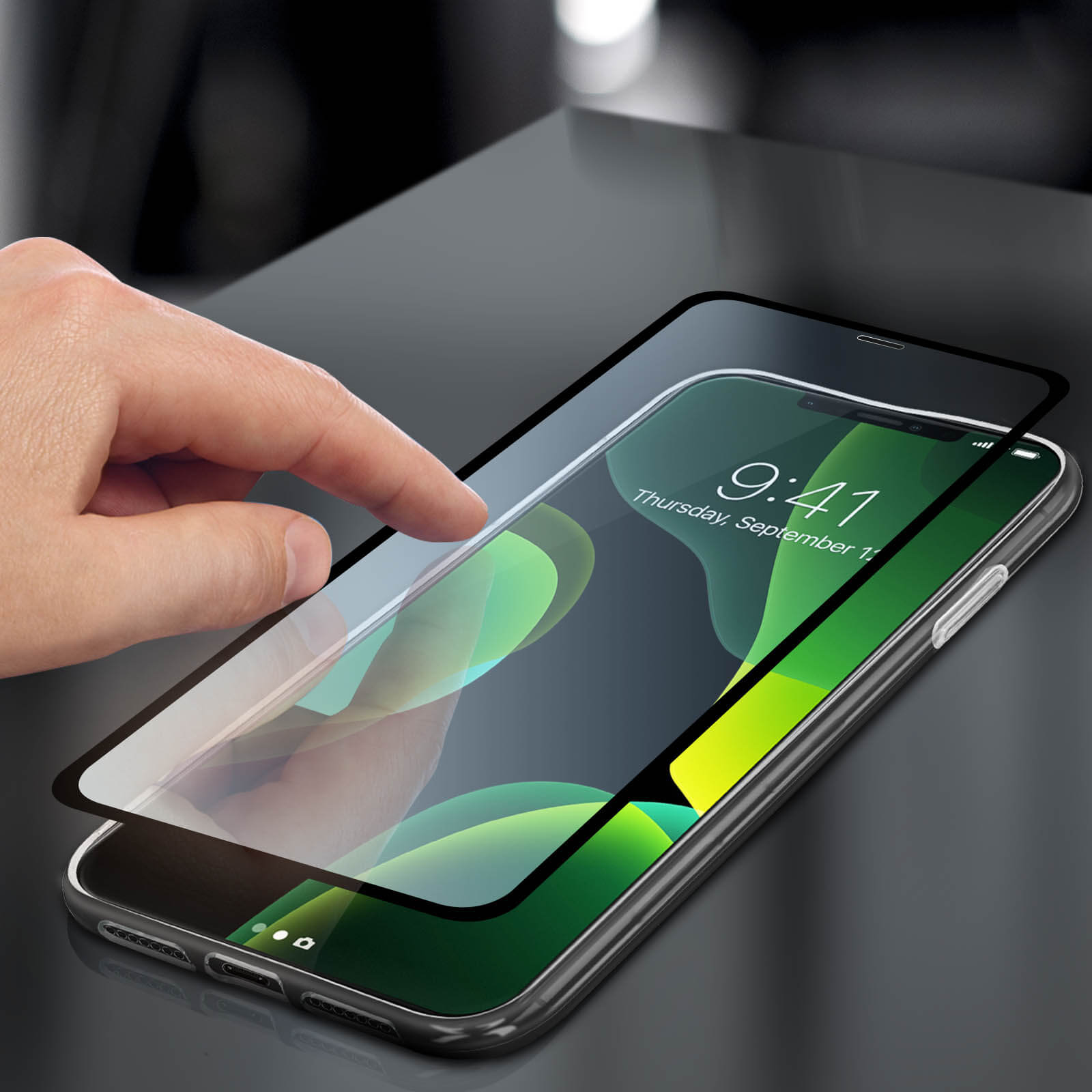 Eine Hand, die einen Displayschutz auf ein Telefon legt. Das Telefon zeigt die Uhrzeit 9:41 Uhr an.
