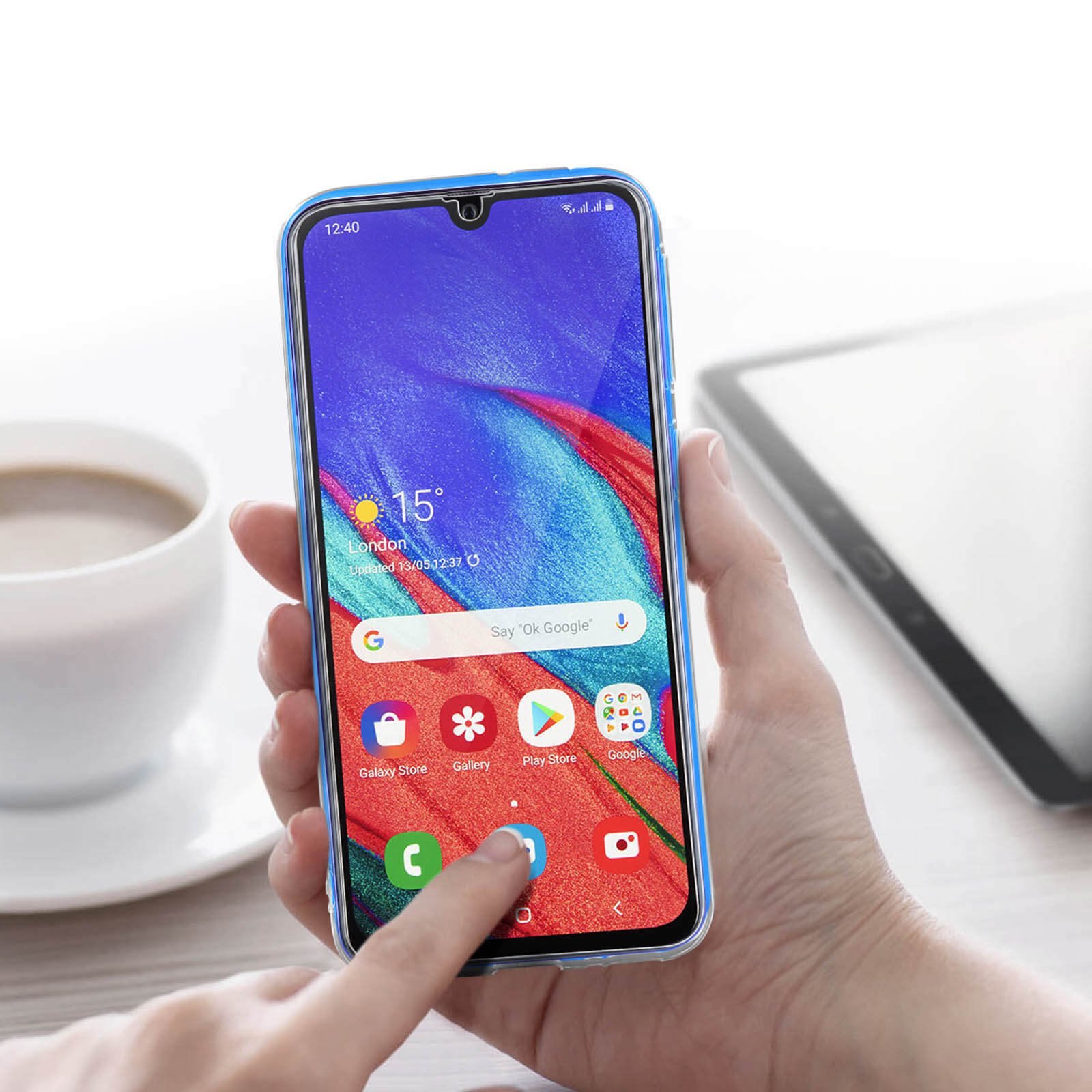 Mano che tiene uno smartphone con custodia blu. Il telefono mostra un'app meteo.