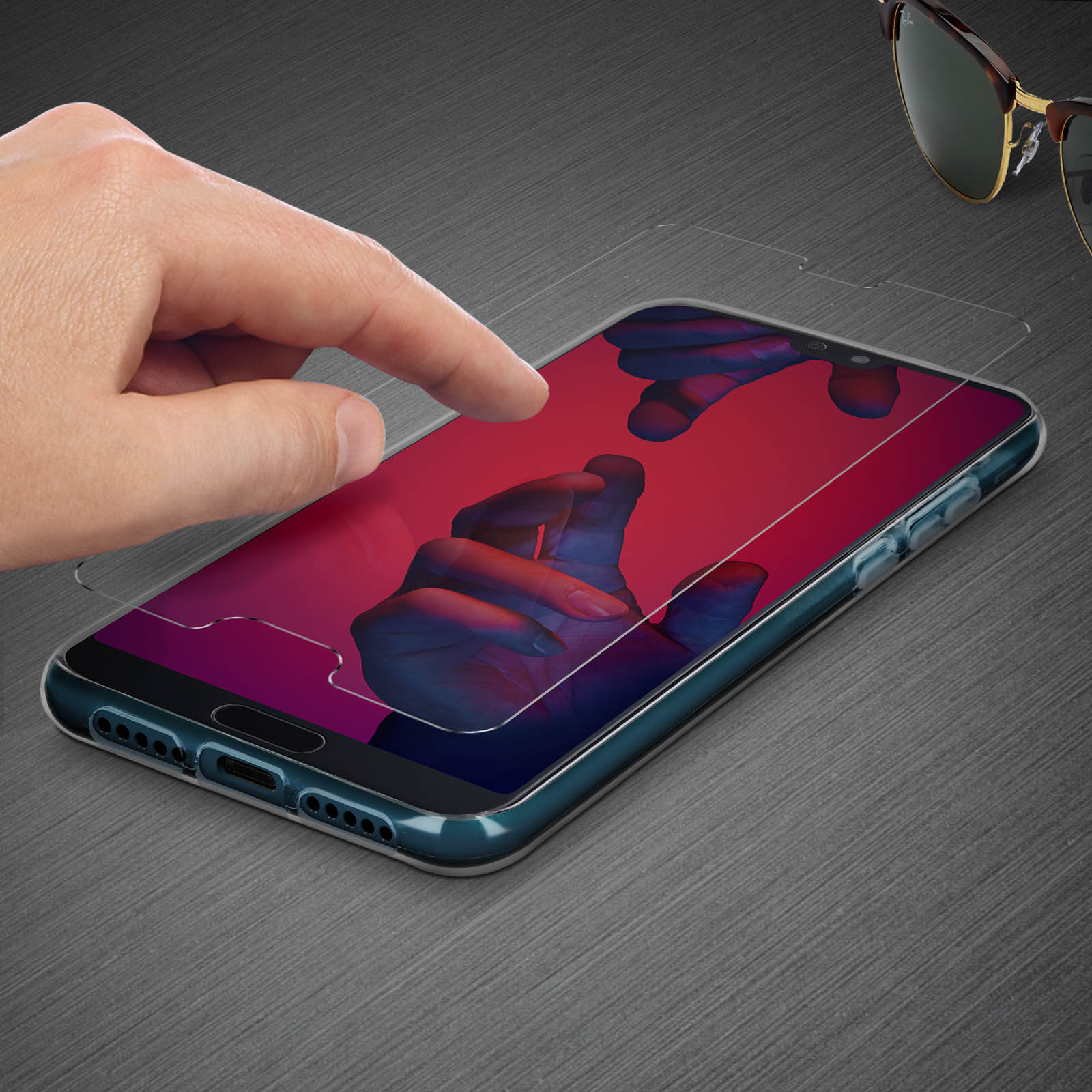 Mano che tocca lo schermo del telefono con una protezione. Occhiali da sole sullo sfondo.