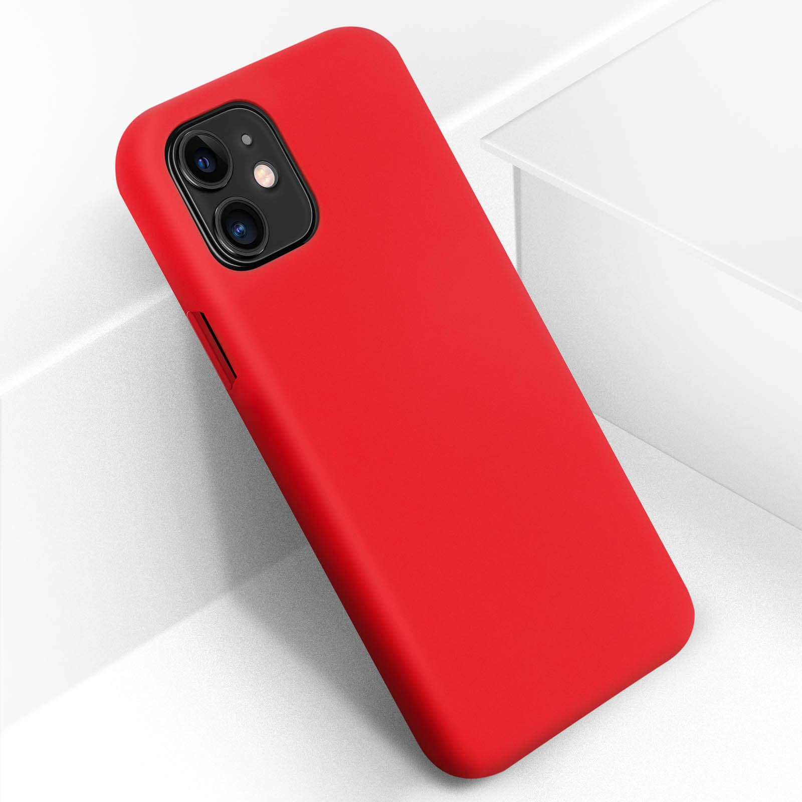 Coque de téléphone rouge sur une surface blanche. Le téléphone a une section de caméra noire. La coque est rouge.