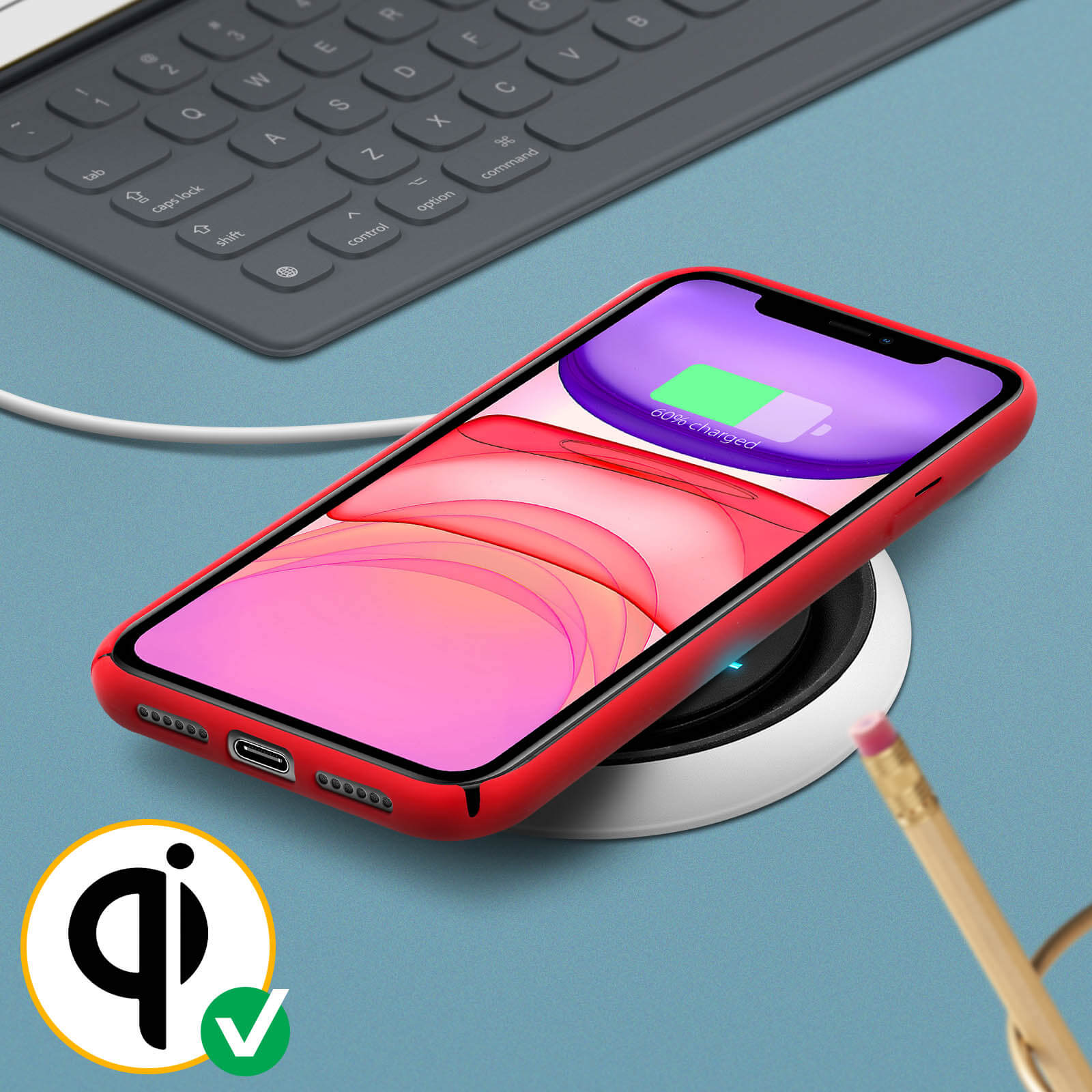 Téléphone rouge sur chargeur sans fil, 60% chargé. Clavier en arrière-plan.