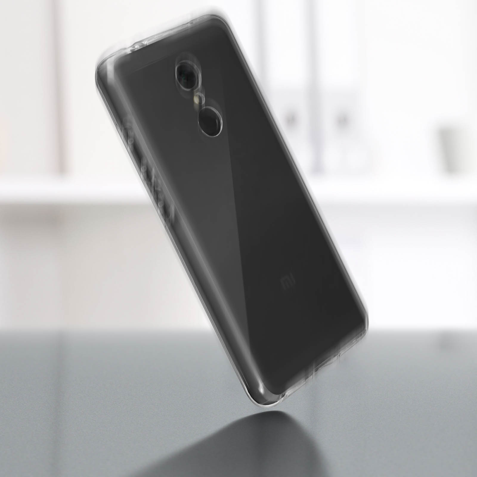 Un teléfono negro con una funda transparente. El teléfono está centrado y ligeramente inclinado.