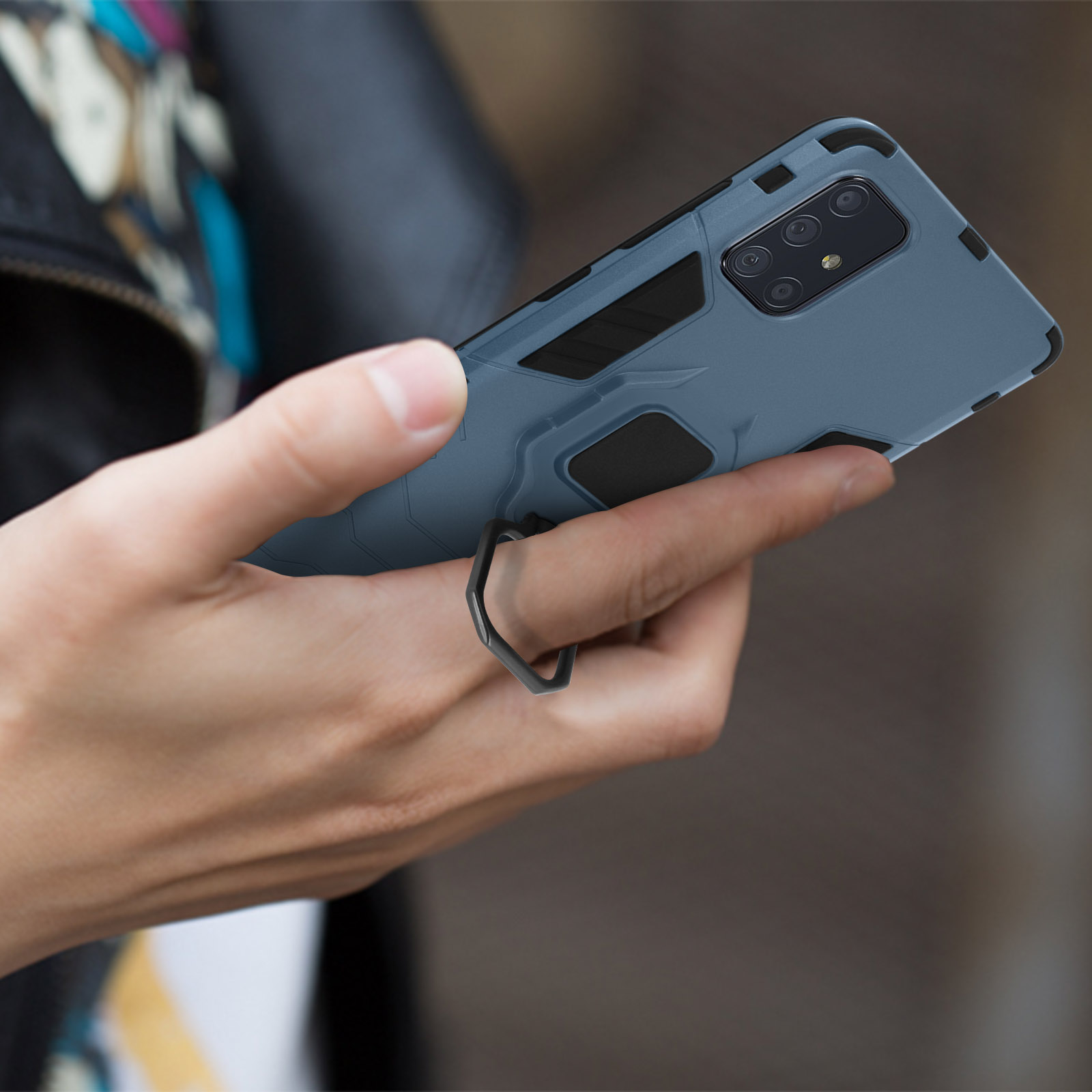 Coque de téléphone bleue avec un anneau, tenue par une personne.