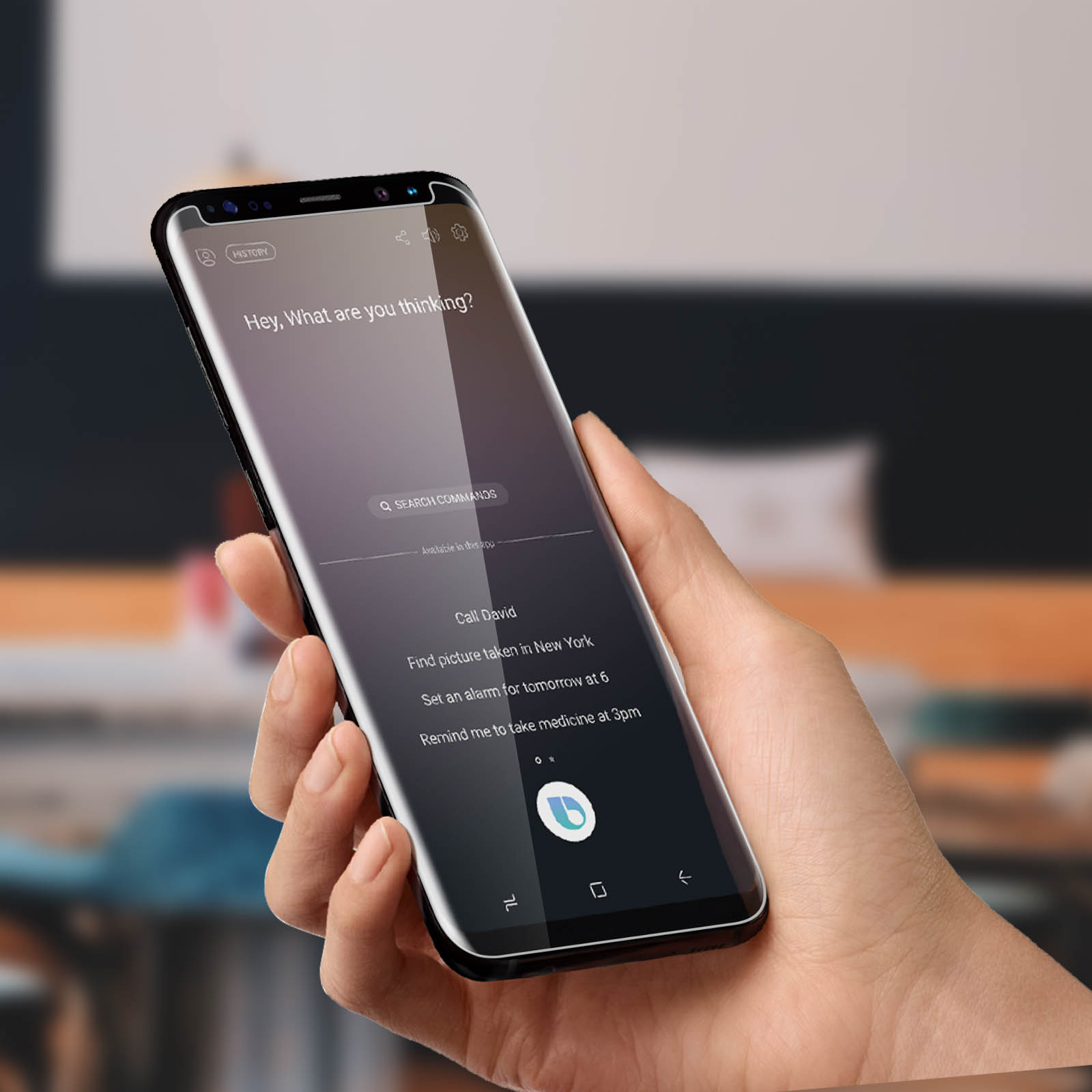 Mano che tiene un telefono con uno schermo di assistente vocale. Lo sfondo è sfocato.