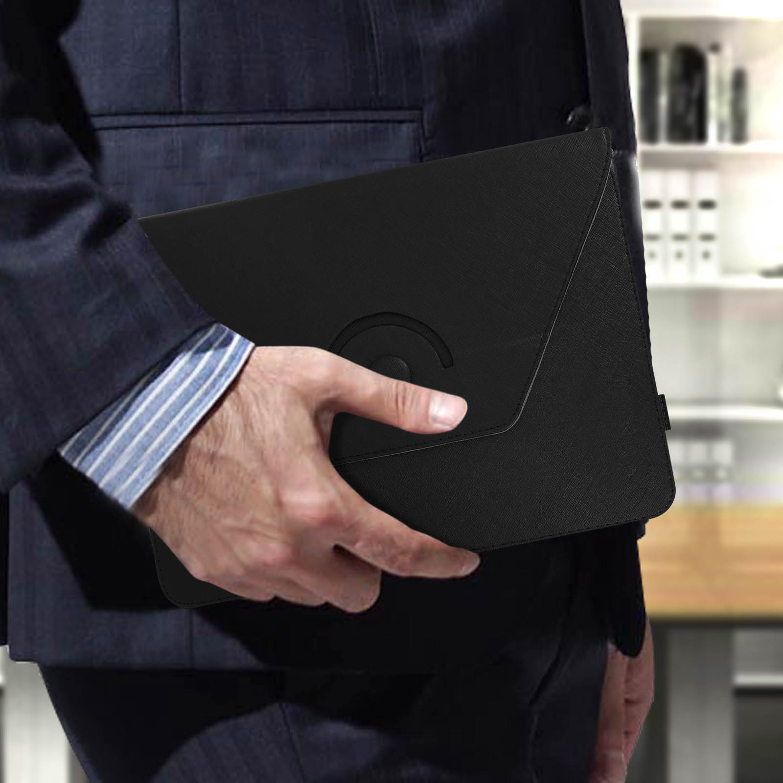 Una persona in giacca e cravatta tiene una custodia nera con un logo, in un ambiente d'ufficio.