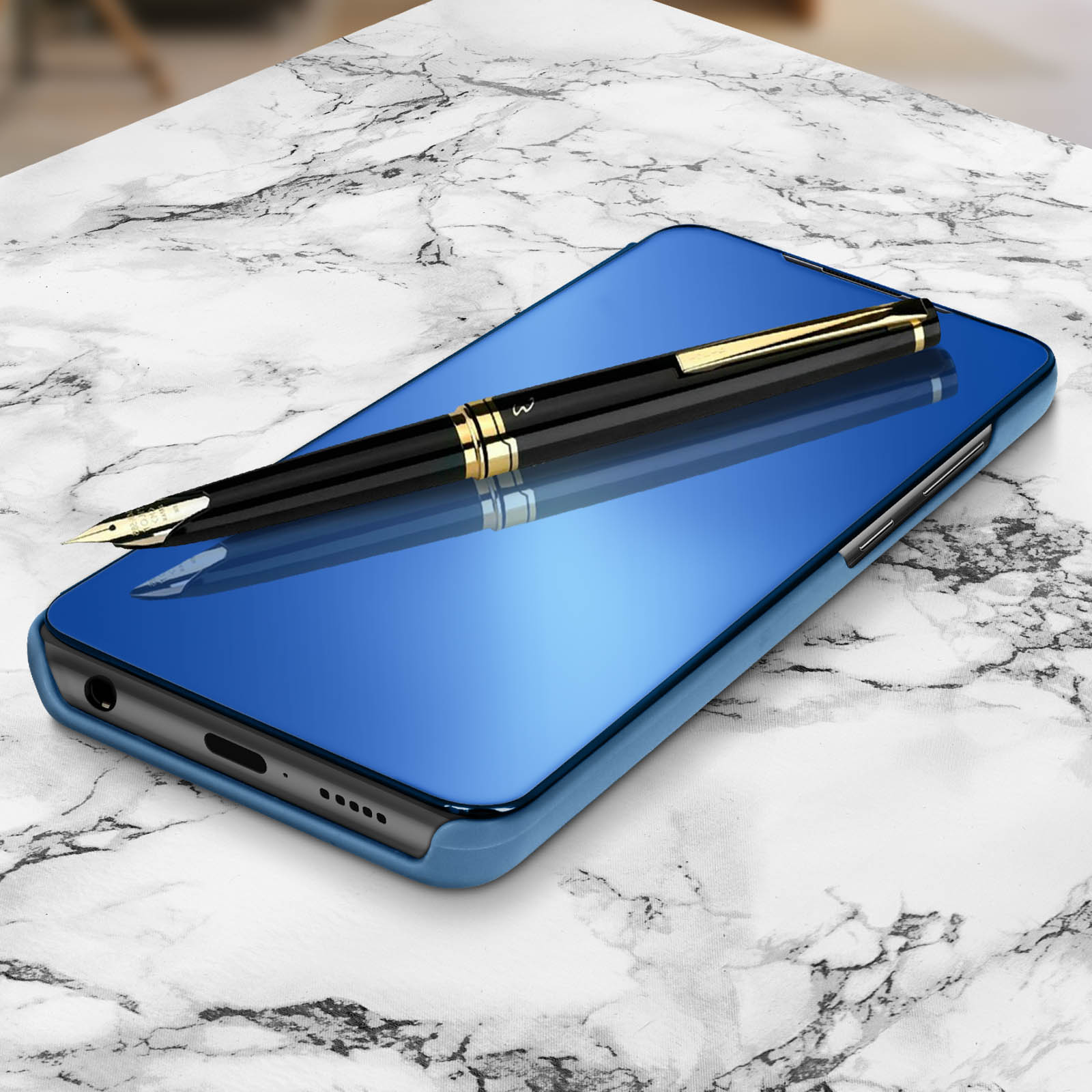 Telefono blu a specchio con penna nera su superficie marmorea, che mostra il riflesso.