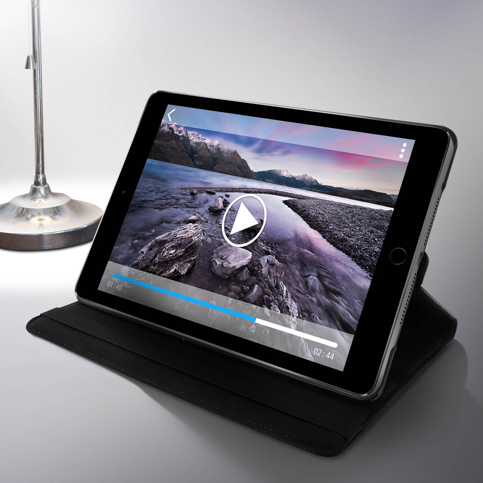 Un tablet che riproduce un video è su un tavolo. Una lampada da tavolo è a sinistra.