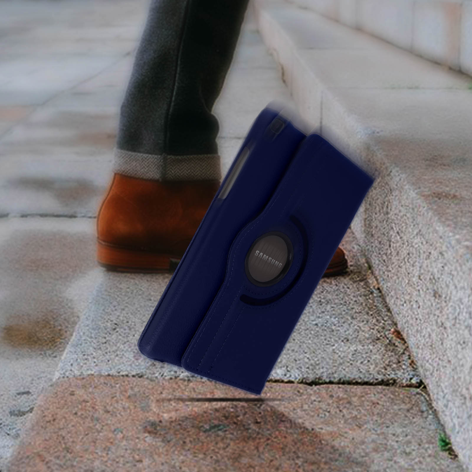 Una custodia blu per tablet che cade sulle scale. La custodia è aperta. La gamba di una persona sullo sfondo.