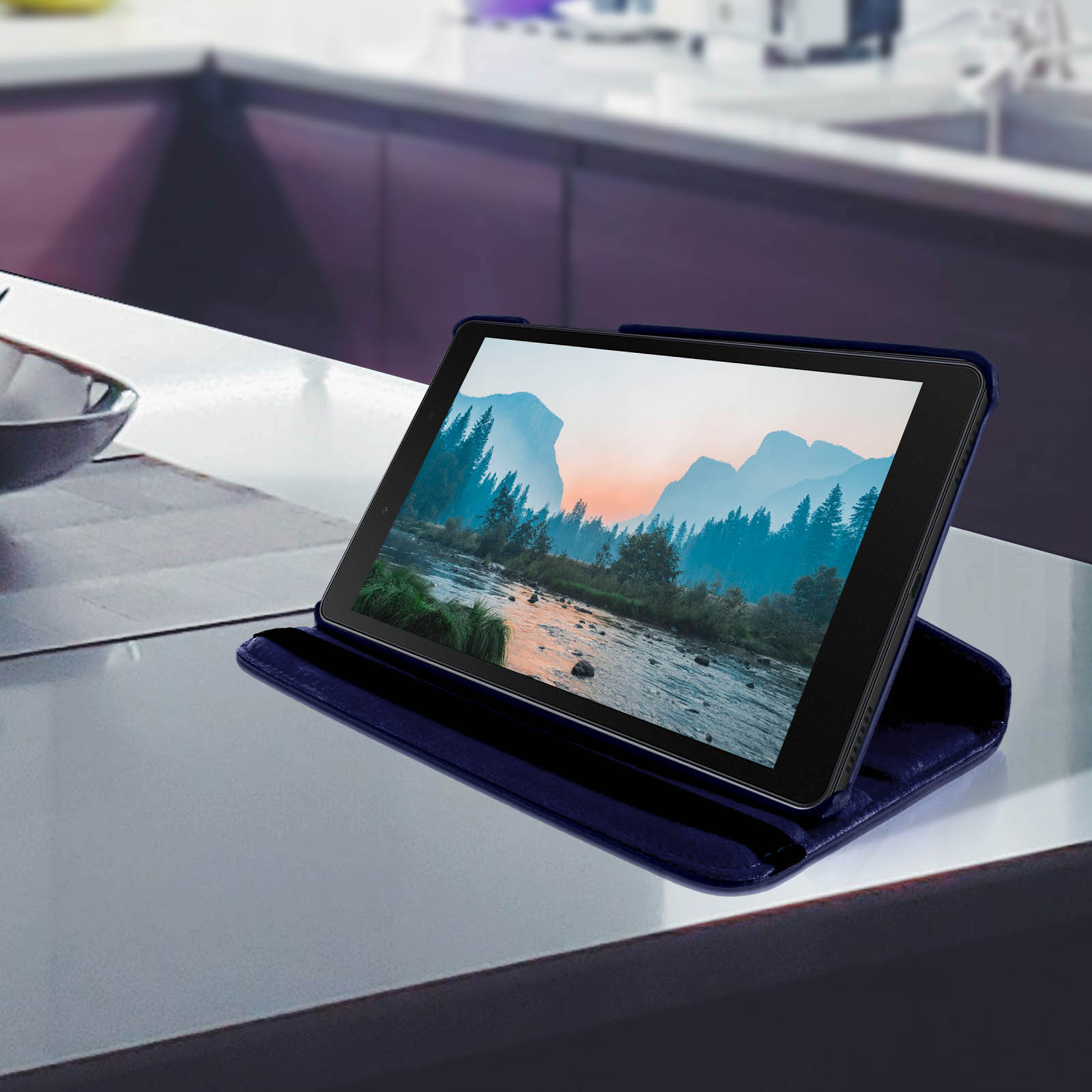 Un tablet in una custodia blu, che mostra un'immagine di paesaggio, posto su una superficie bianca.
