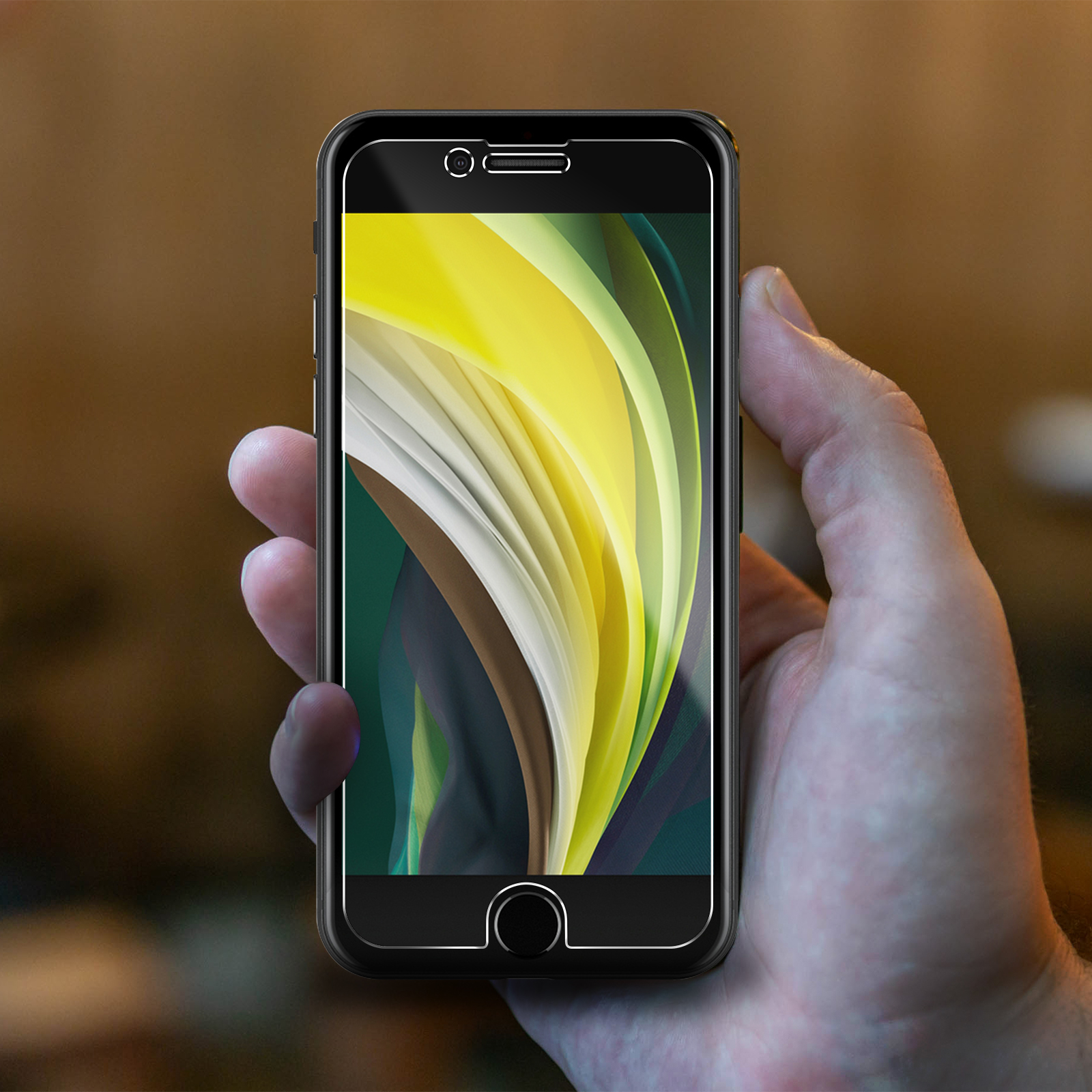 Una mano che tiene un telefono nero, schermo acceso. Lo schermo mostra un design astratto colorato con giallo e verde.