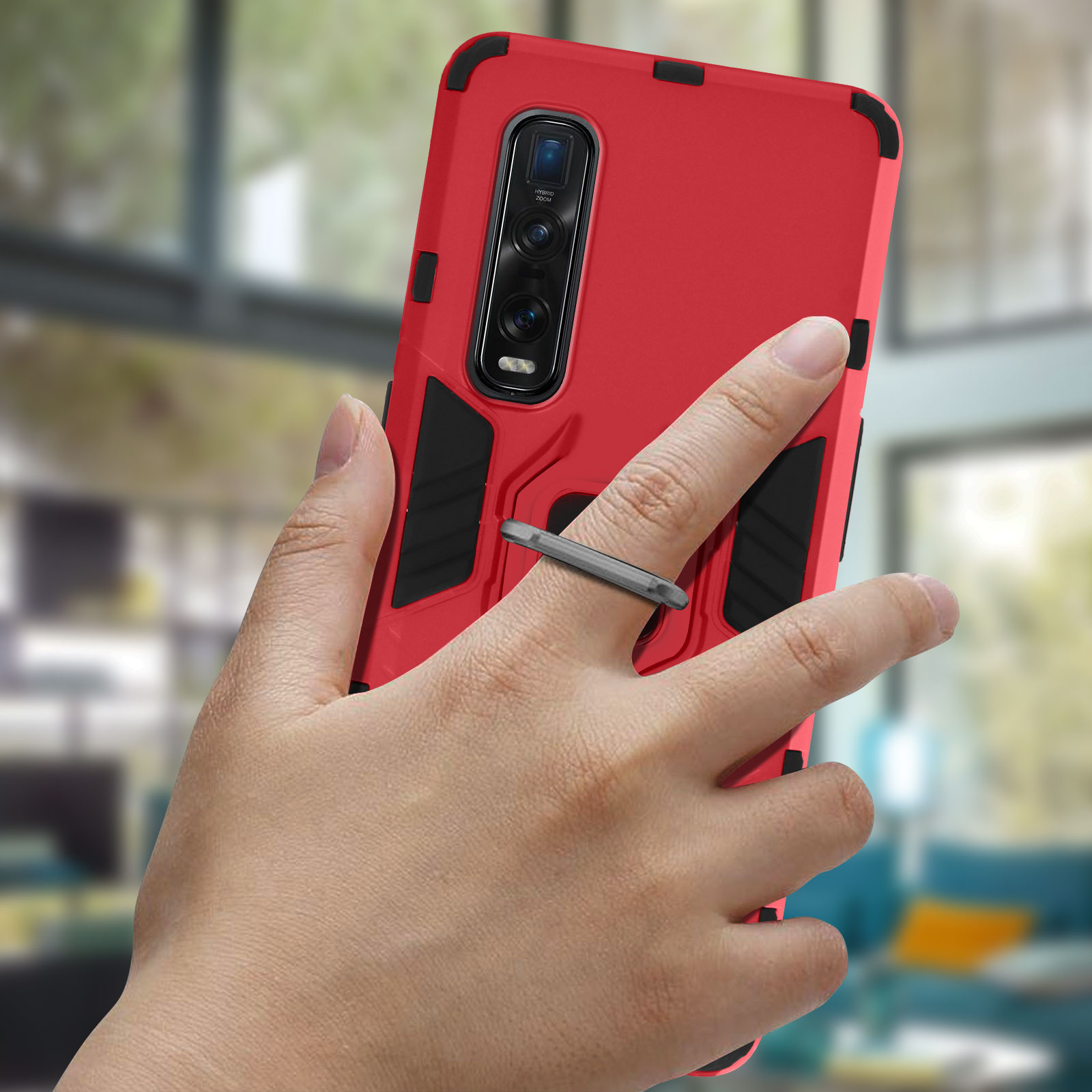 Mano che tiene una custodia rossa con un anello. Lo sfondo è un soggiorno sfocato.