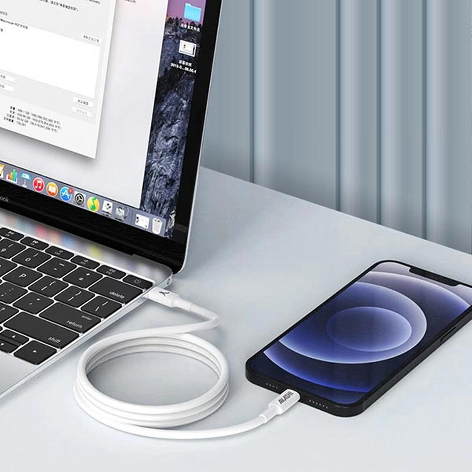Un laptop collegato a un telefono con un cavo di ricarica bianco. Il telefono è su un tavolo.