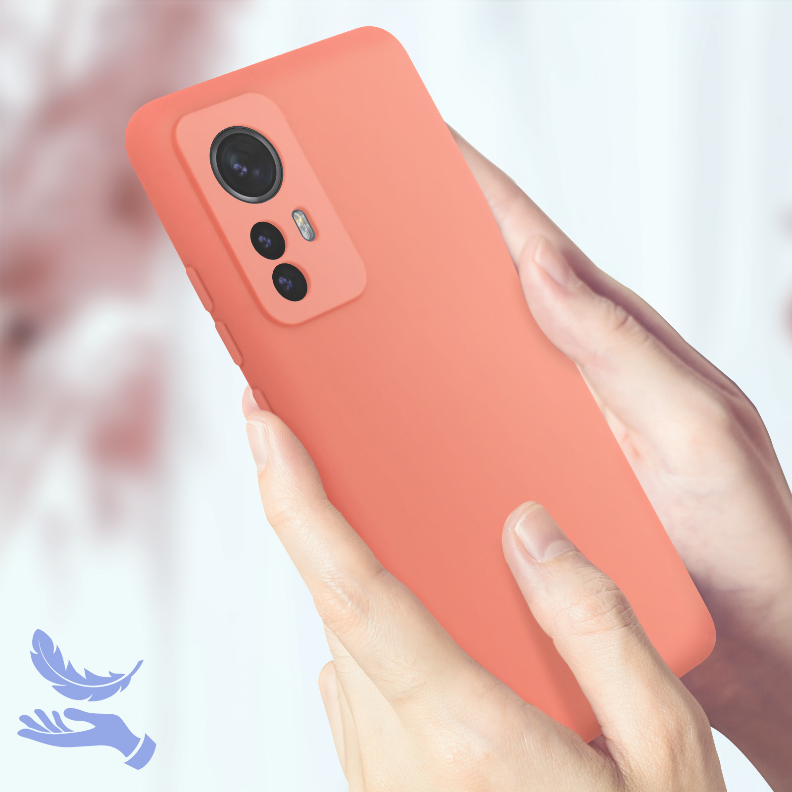 Un telefono color pesca tenuto dalle mani, con un'icona di piuma nell'angolo.
