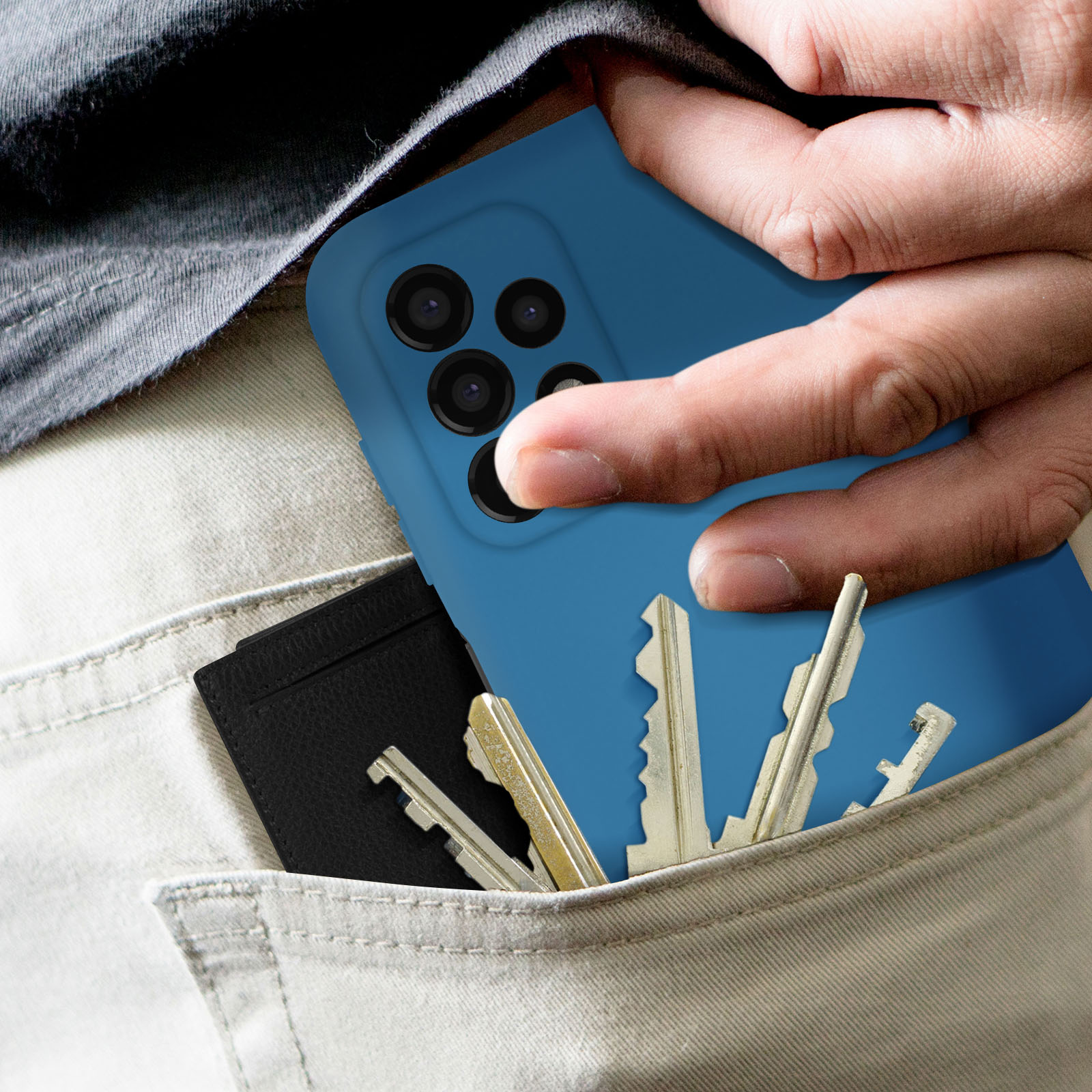 Een hand die een blauwe telefoon vasthoudt. Sleutels en een zwarte portemonnee in de zak.