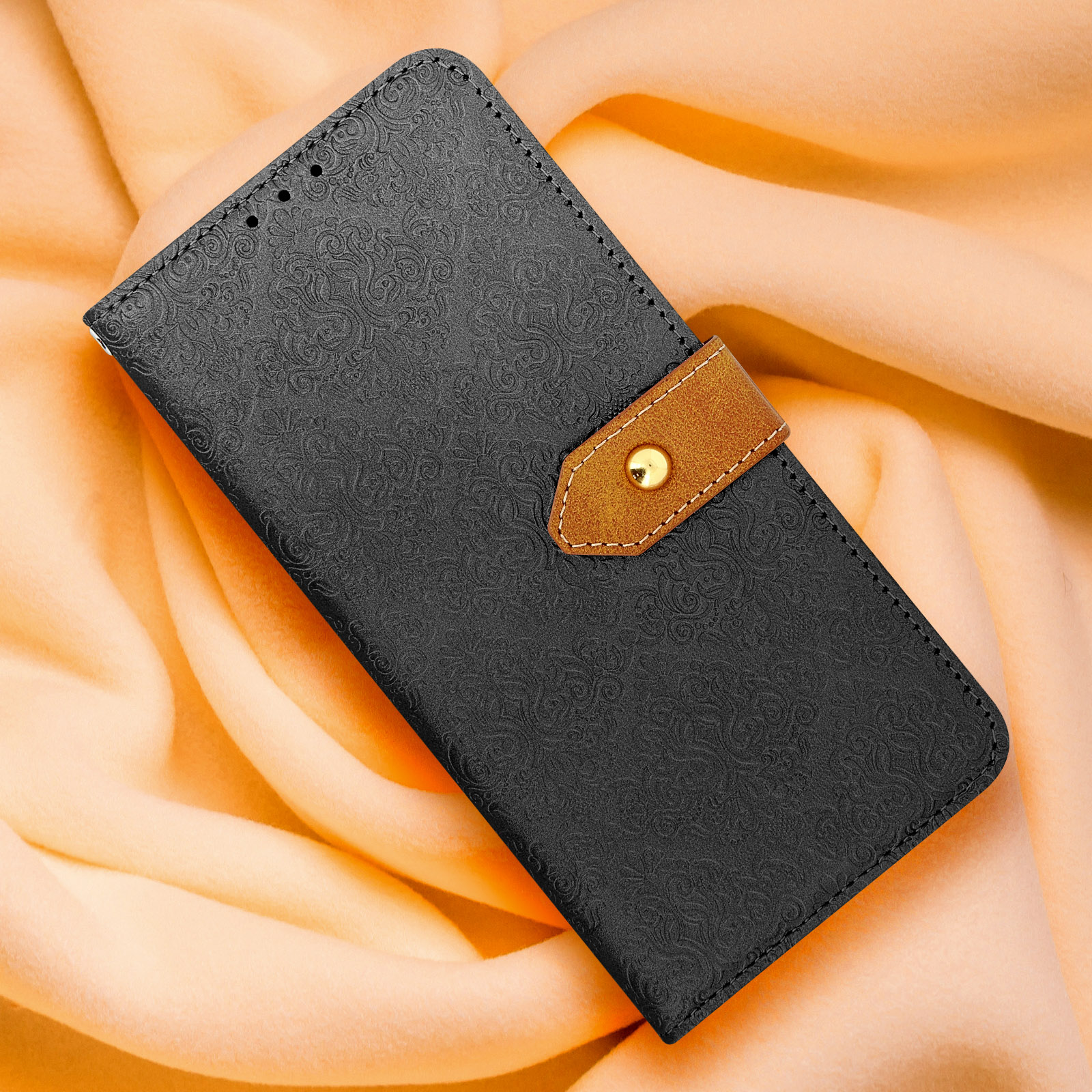 Coque de téléphone noire avec un rabat marron simili cuir. La coque est sur une surface jaune douce.