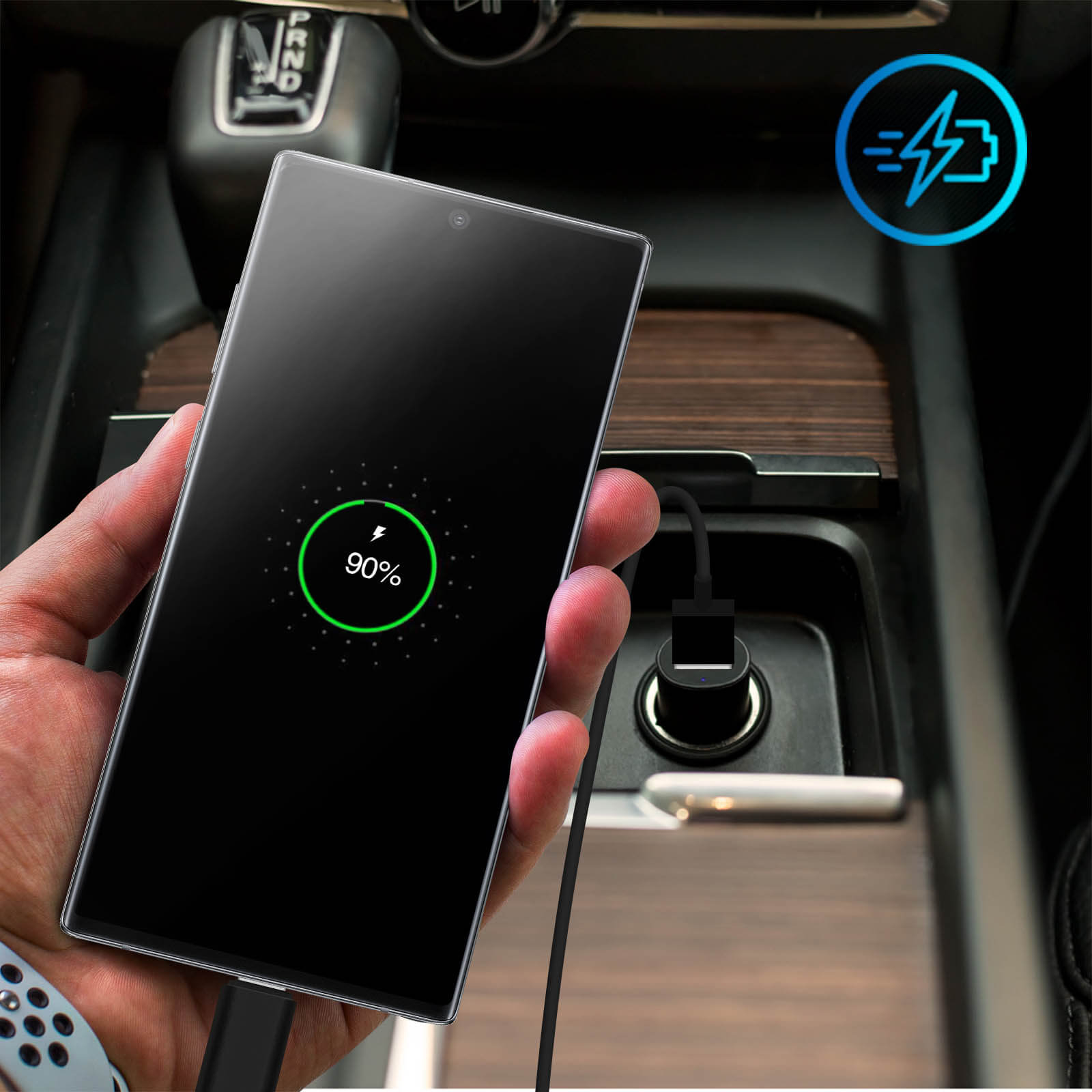 Telefon wird im Auto geladen. Das Telefon zeigt eine Ladeanzeige. Der Innenraum des Autos ist dunkel.
