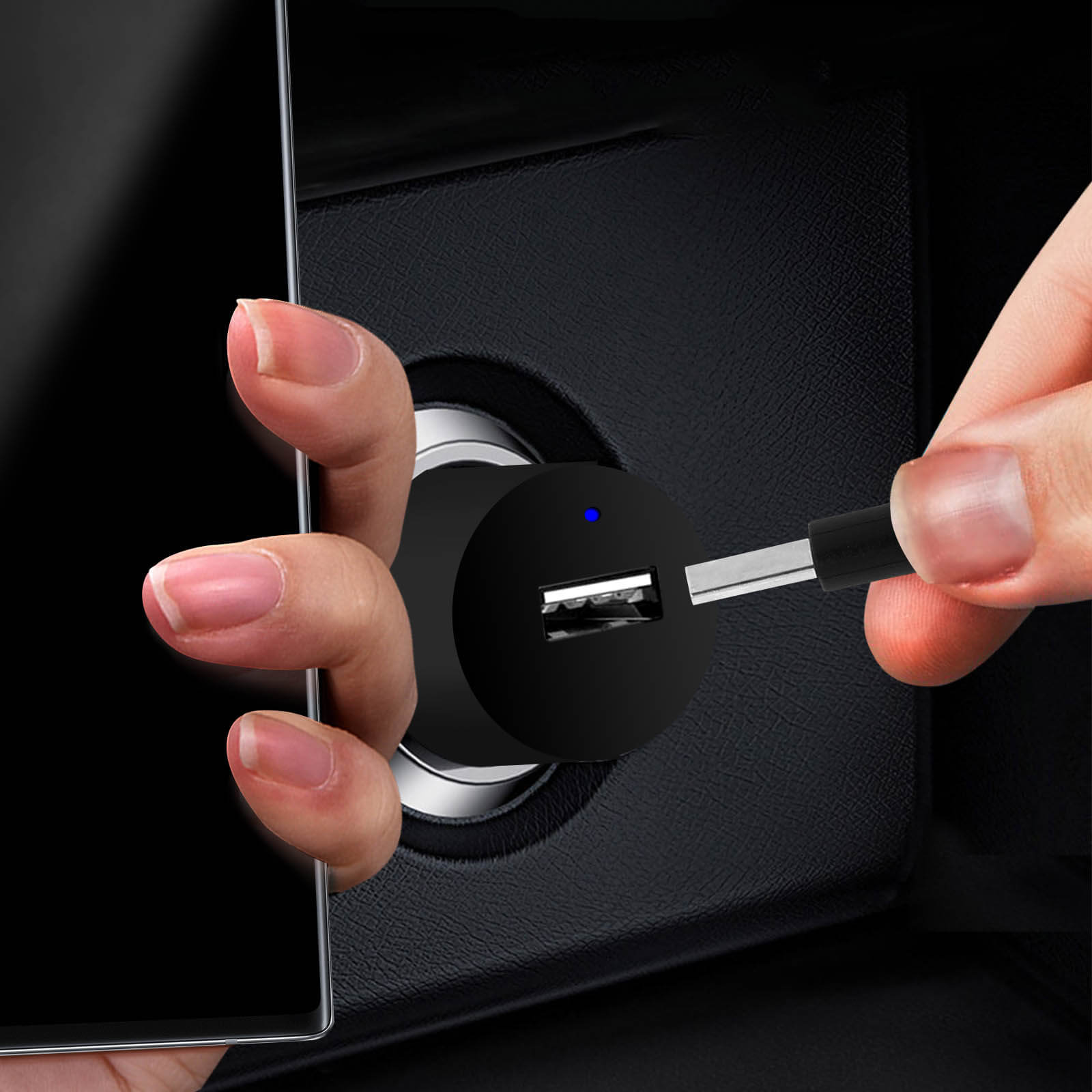 Hand steckt USB-Ladegerät ins Auto. Telefon im Rahmen, schwarzes Ladegerät und Anschluss. Dunkler Innenraum.