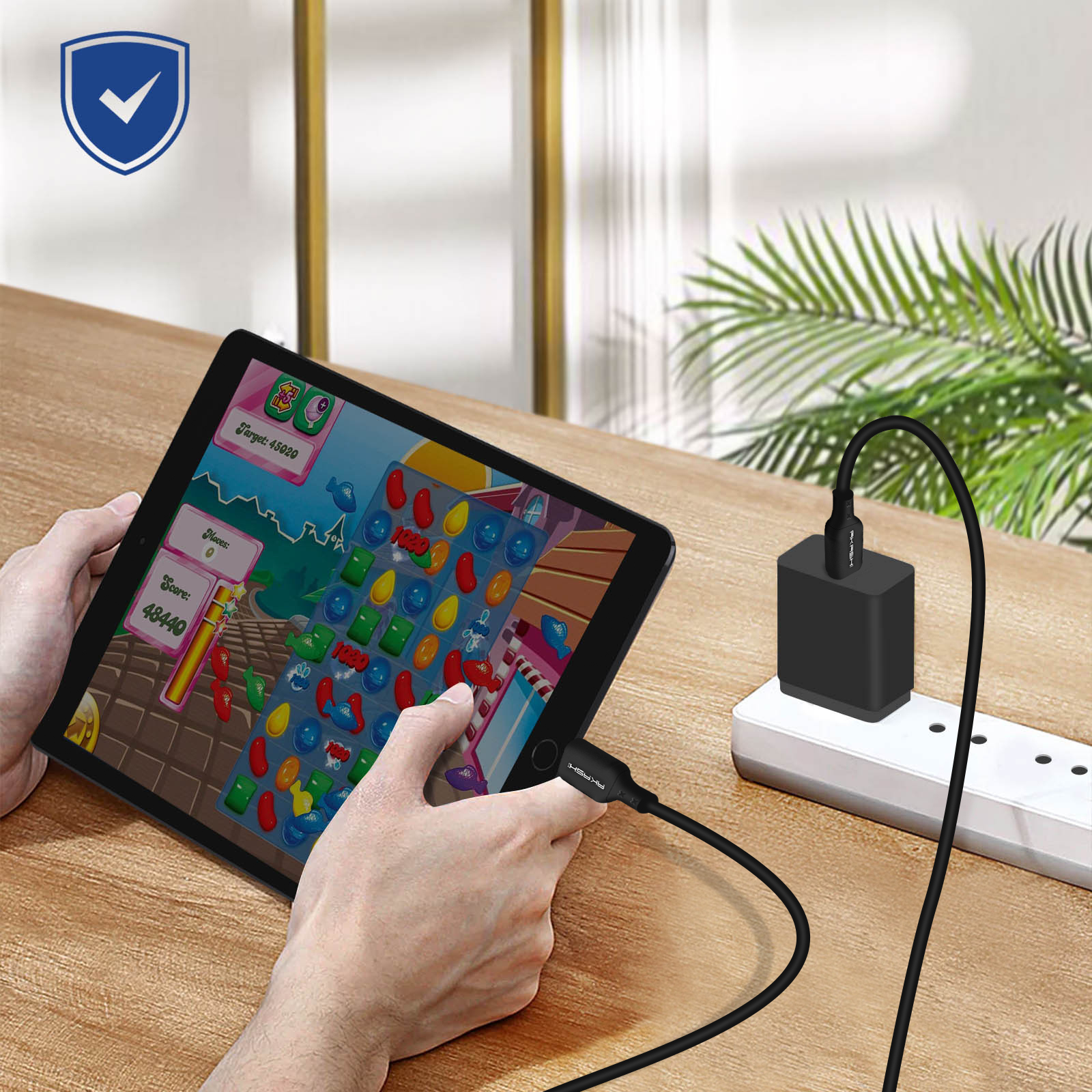 Tablet che mostra un gioco, si ricarica da un adattatore nero su una presa bianca.