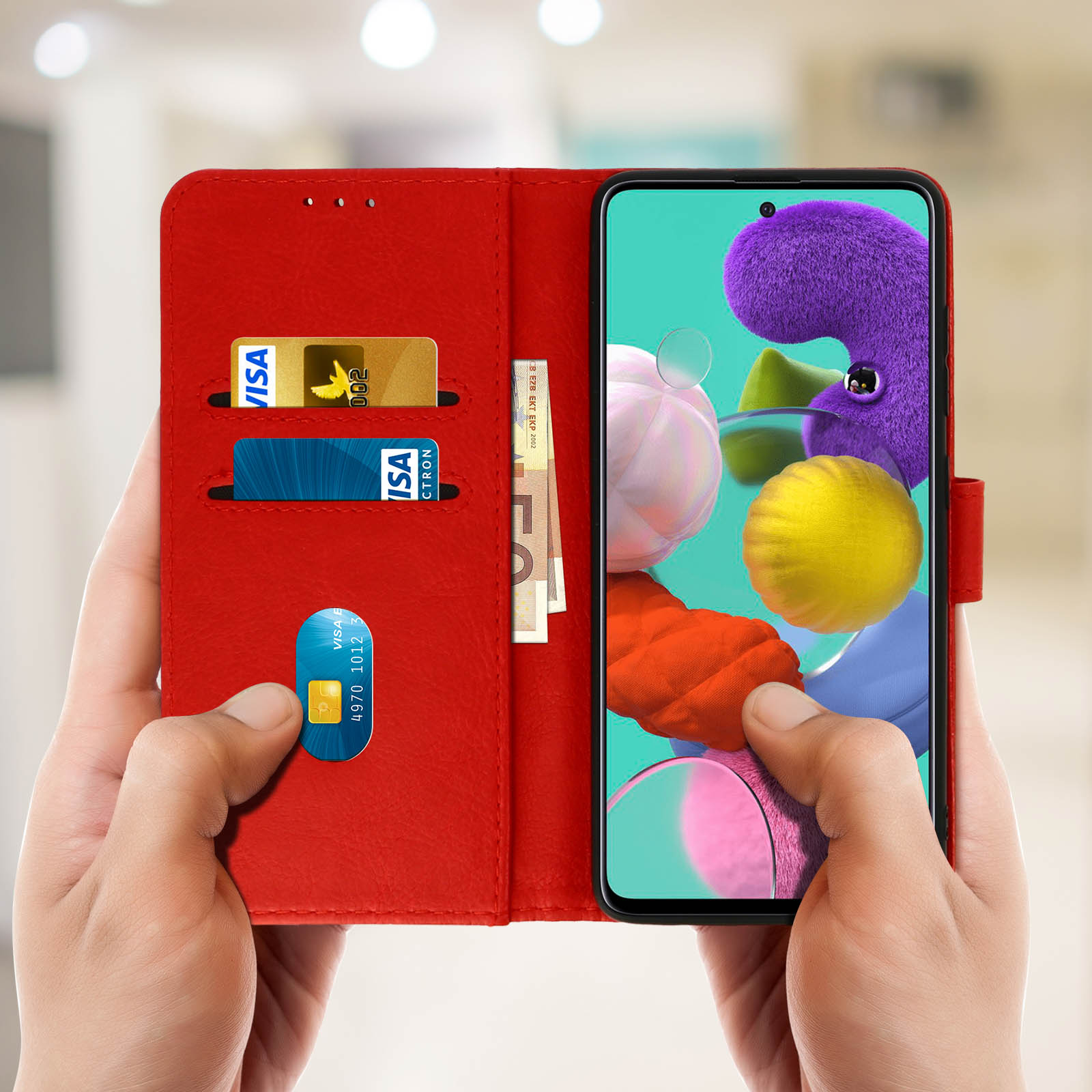 Étui de téléphone rouge, avec cartes et argent à l'intérieur, dans les mains. Un téléphone avec écran violet. Flou.