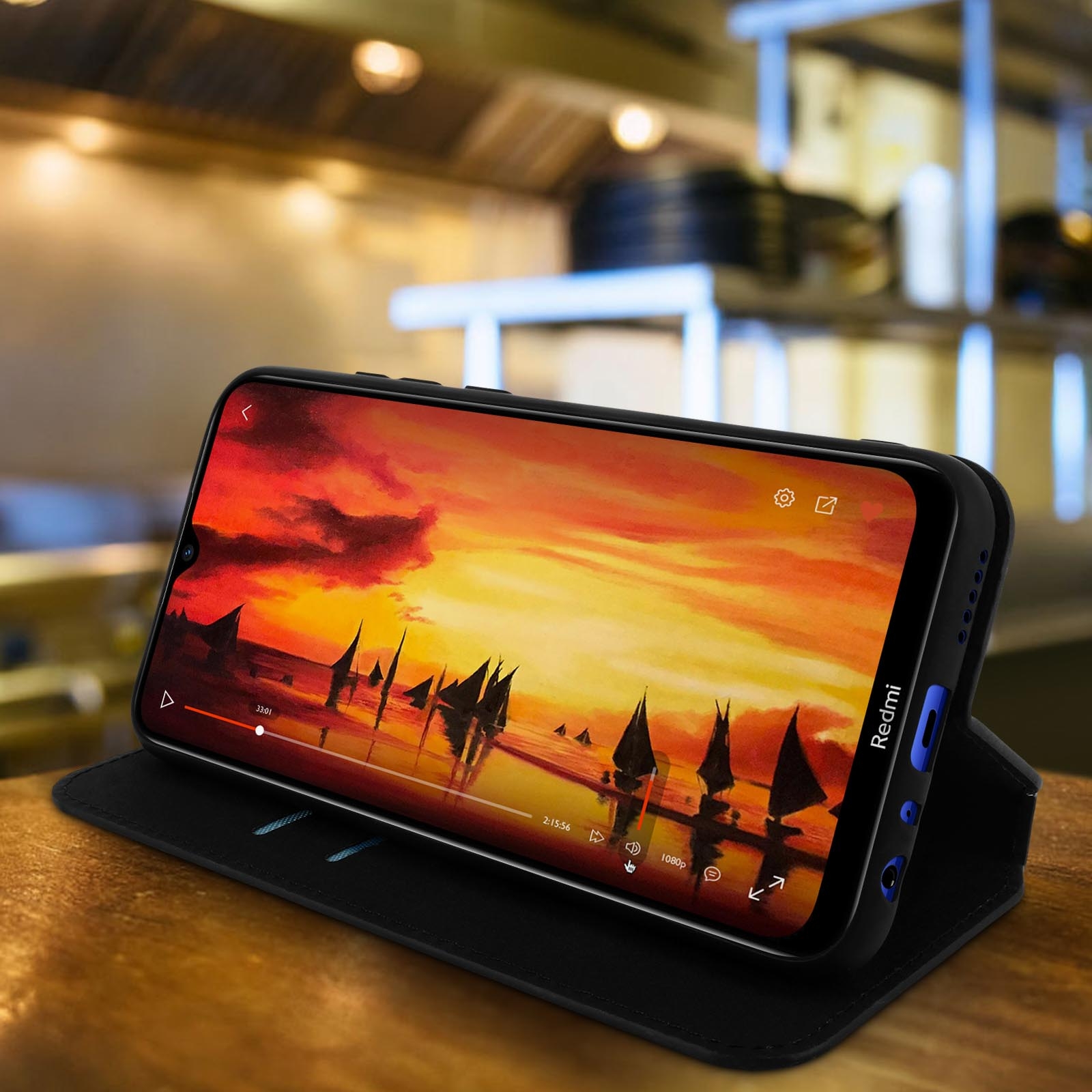 Un telefono in una custodia mostra un'immagine del tramonto. La custodia è aperta, appoggiata.