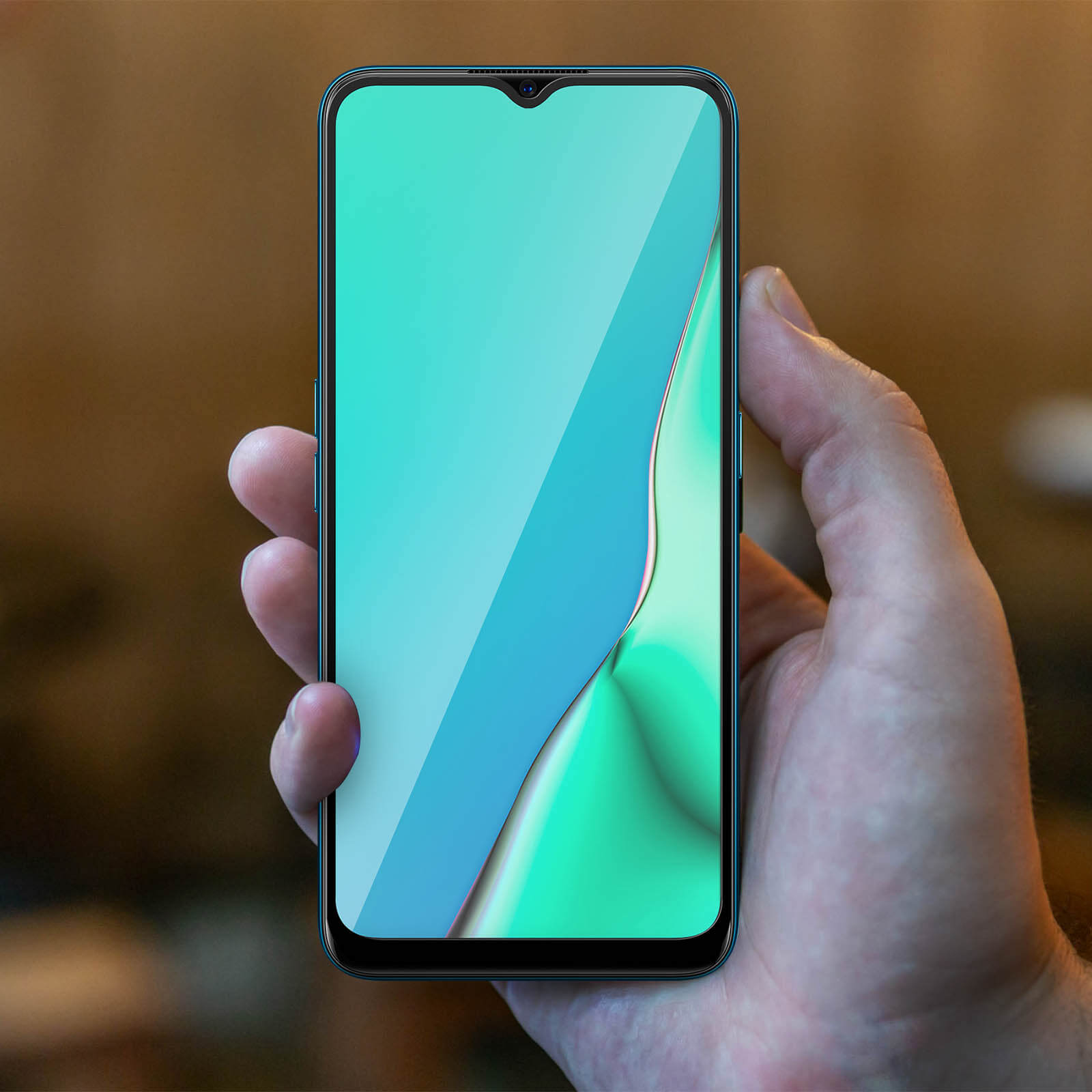 Mano che tiene un telefono con protezione schermo. Schermo verde e blu. Sfondo sfocato.