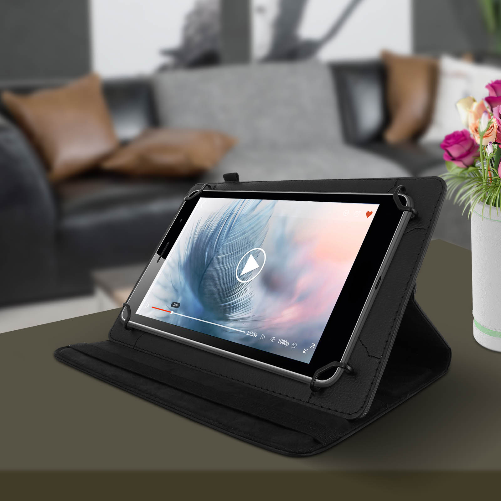 Un tablet in una custodia nera, che mostra un video. Un vaso di fiori è sullo sfondo.
