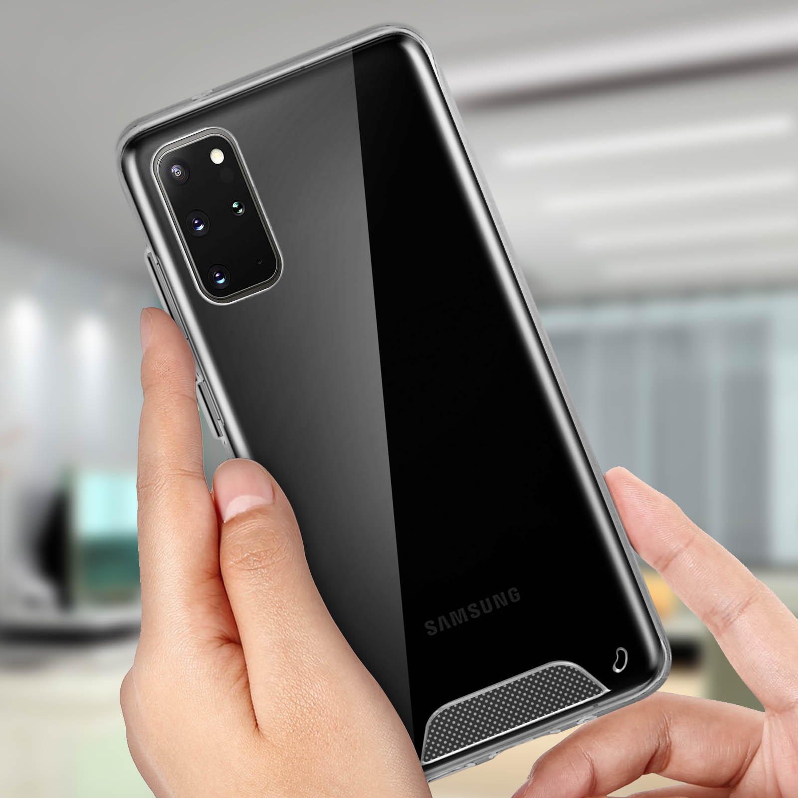 Una mano che tiene un telefono con una custodia trasparente. Lo sfondo è sfocato.