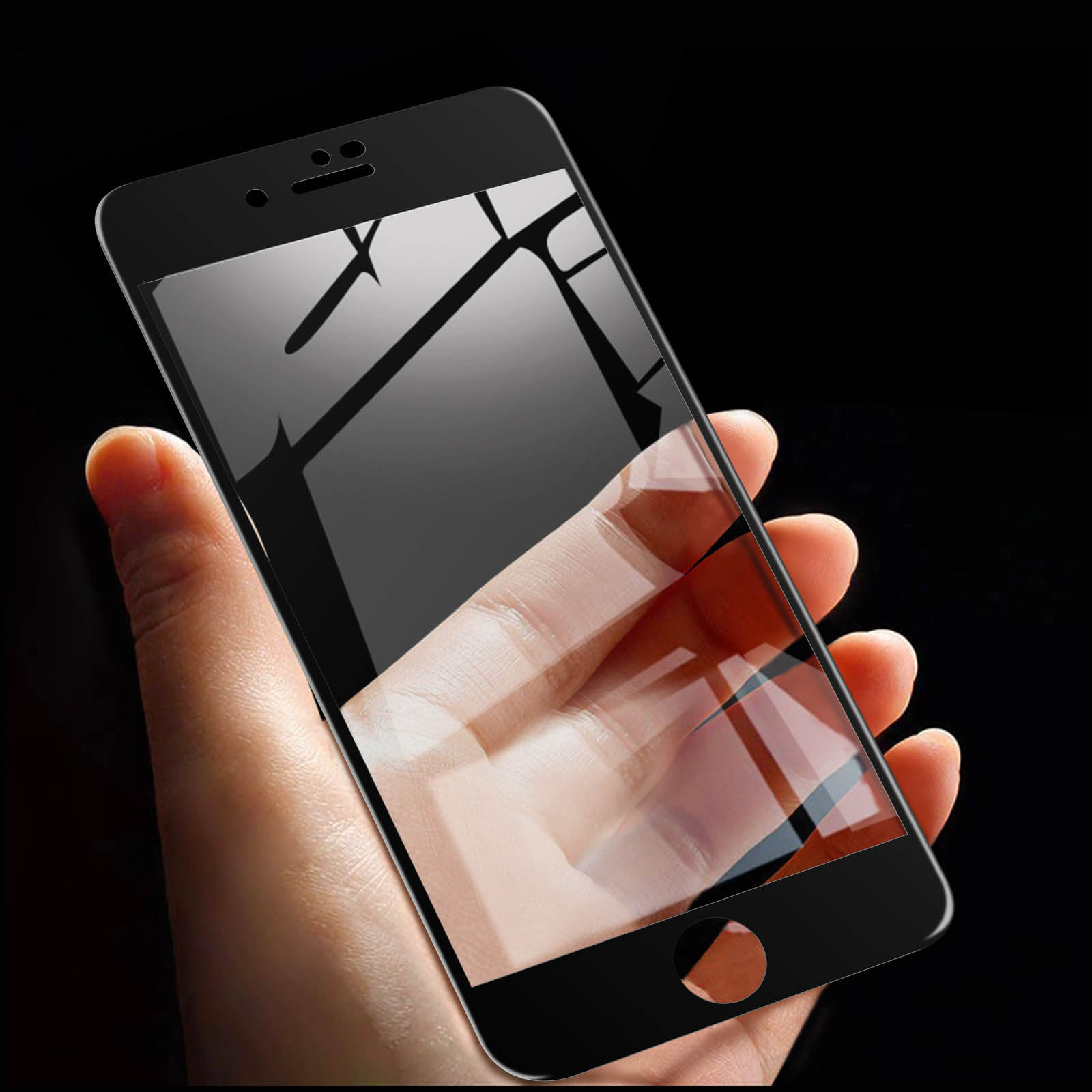 Una mano che tiene un telefono con protezione schermo. Lo schermo è nero e riflette la luce.